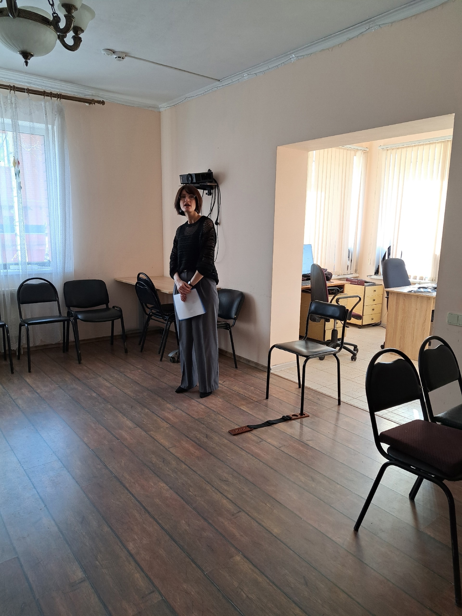Женщина стоит в центре комнаты с бумагами