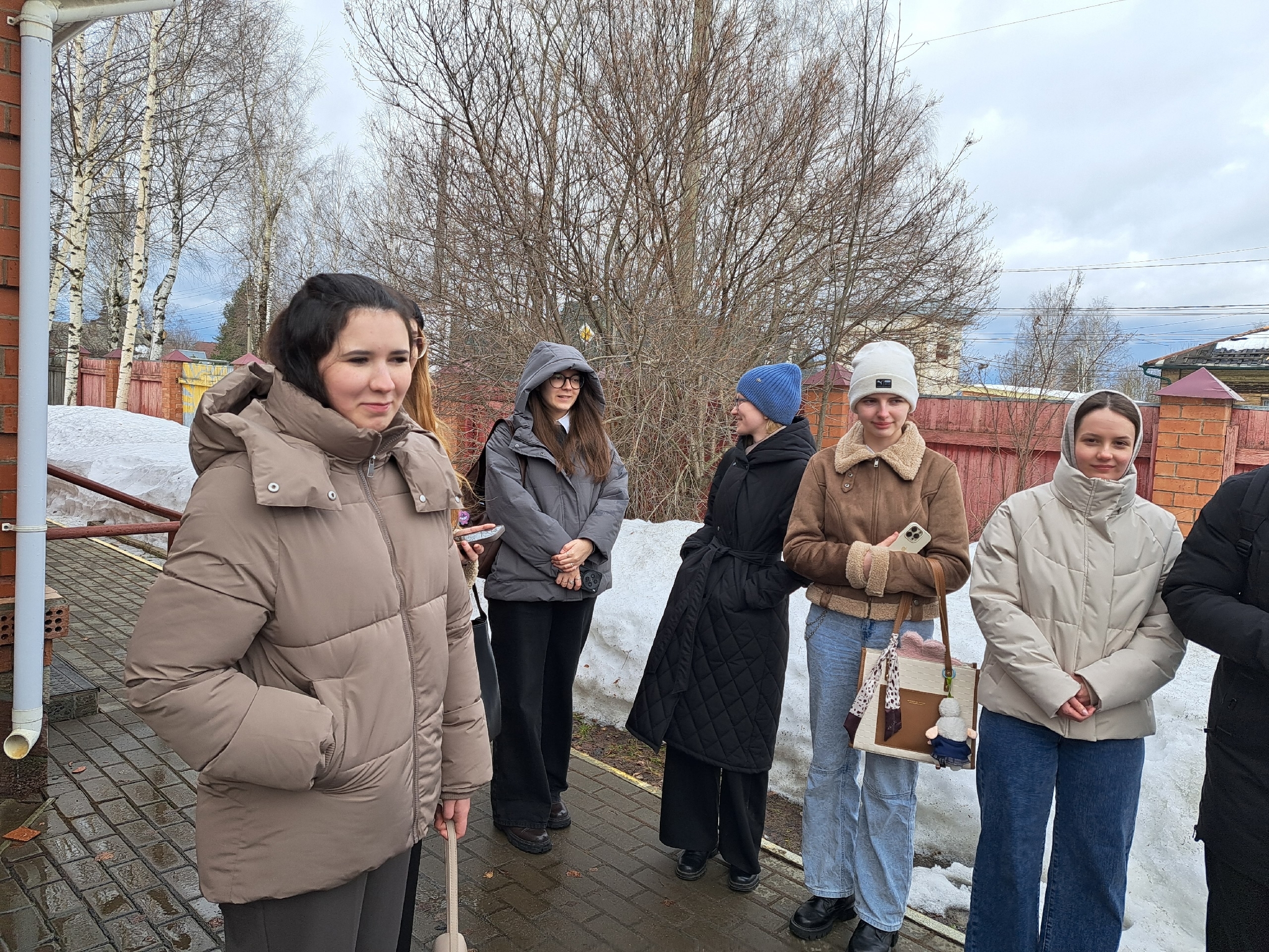 Группа студентов стоит на улице после занятия