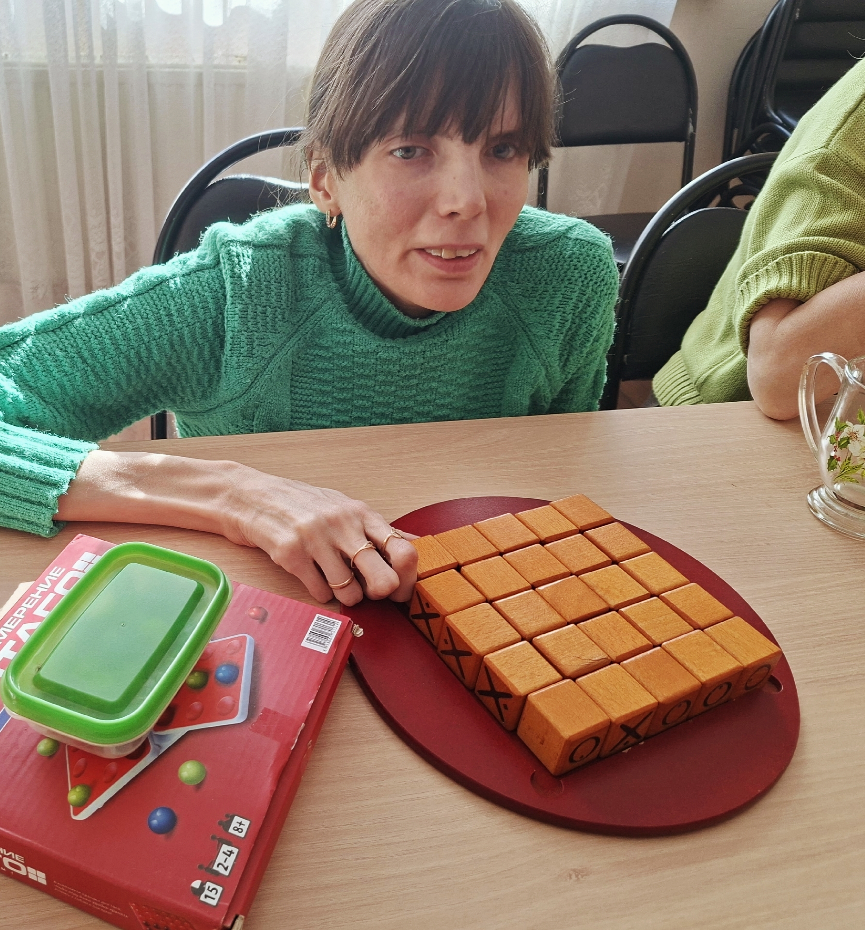 Женщина сидит за столом с настольными играми