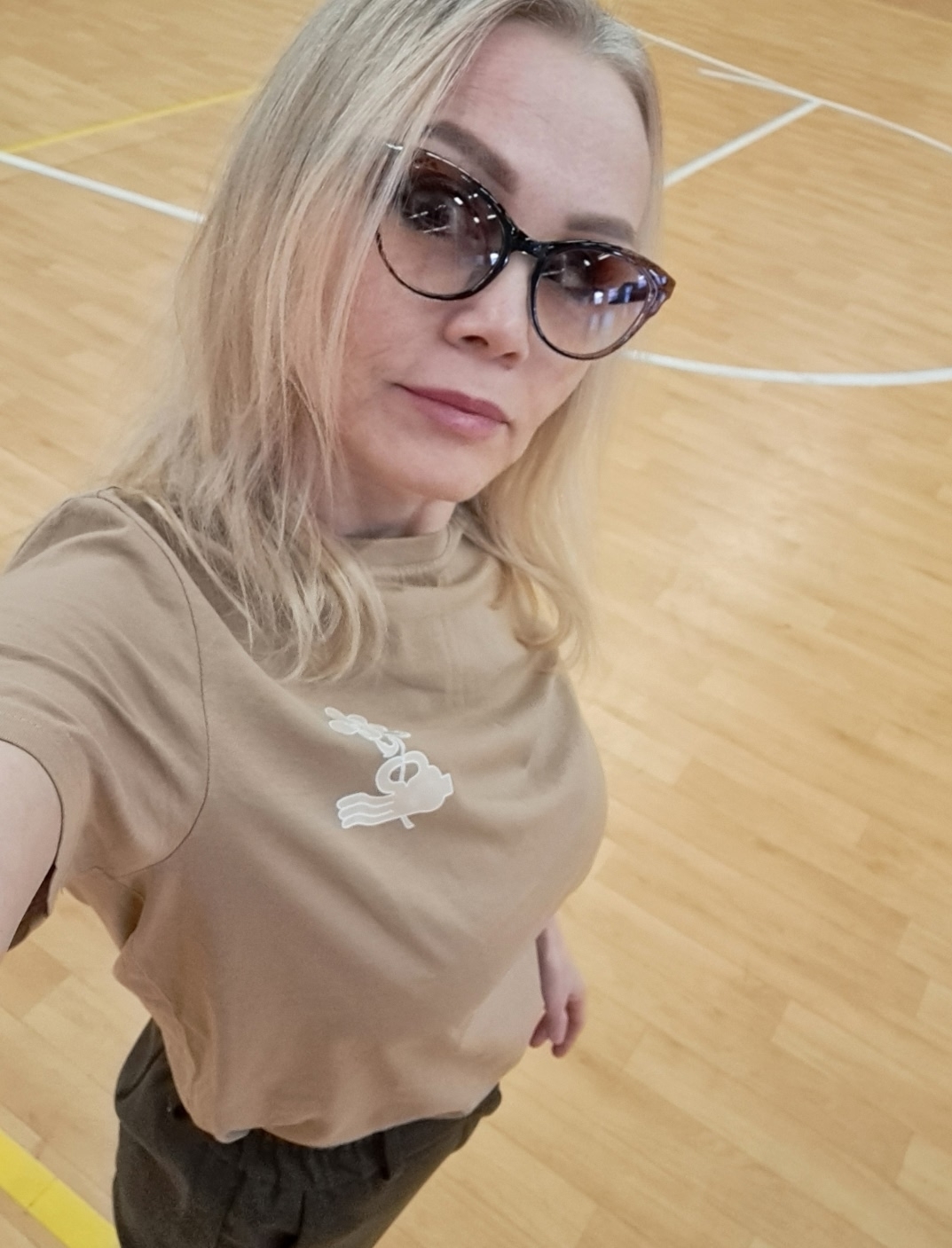 Женщина в очках на волейбольной площадке