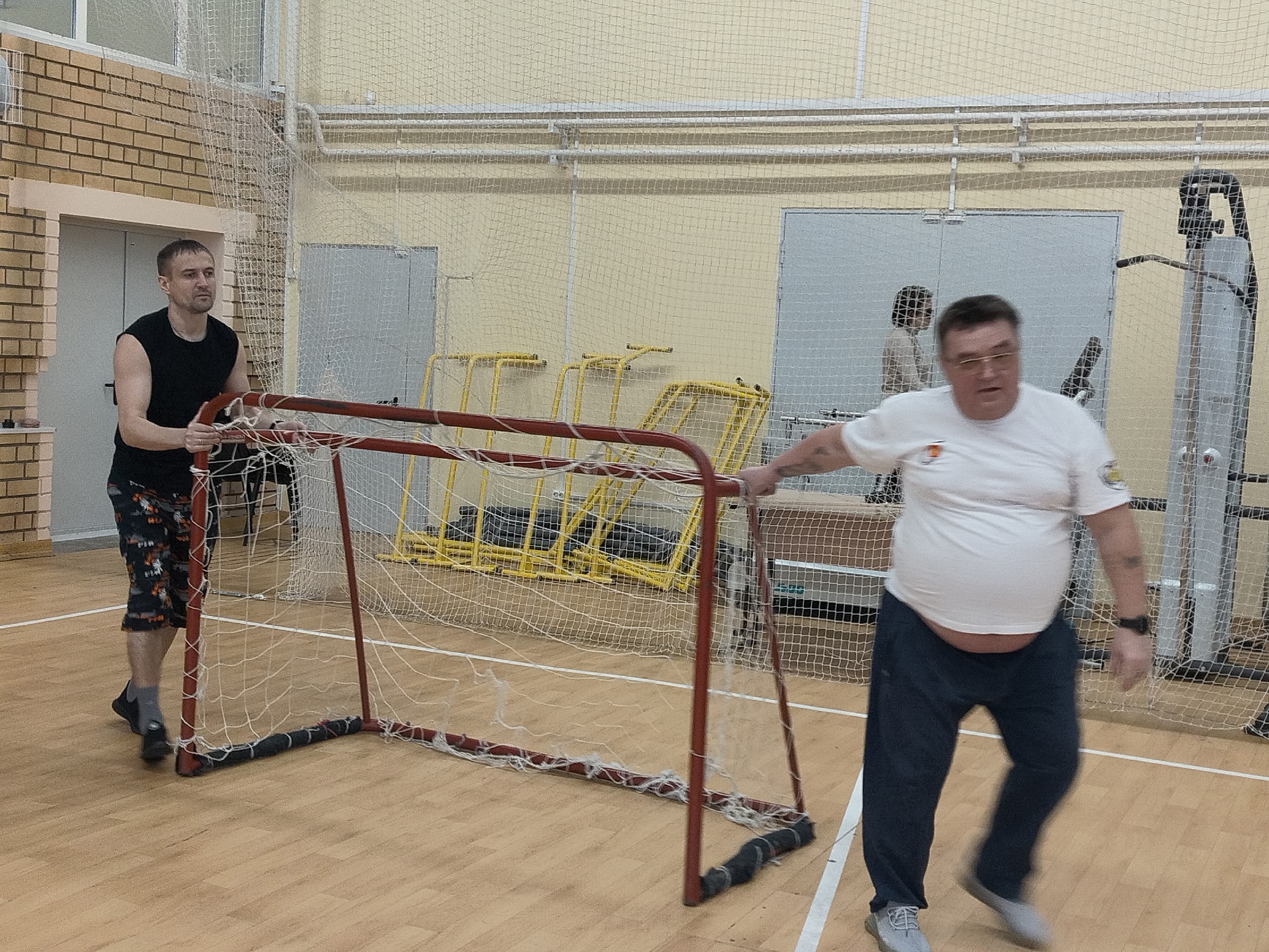 Двое мужчин перемещают небольшие ворота.