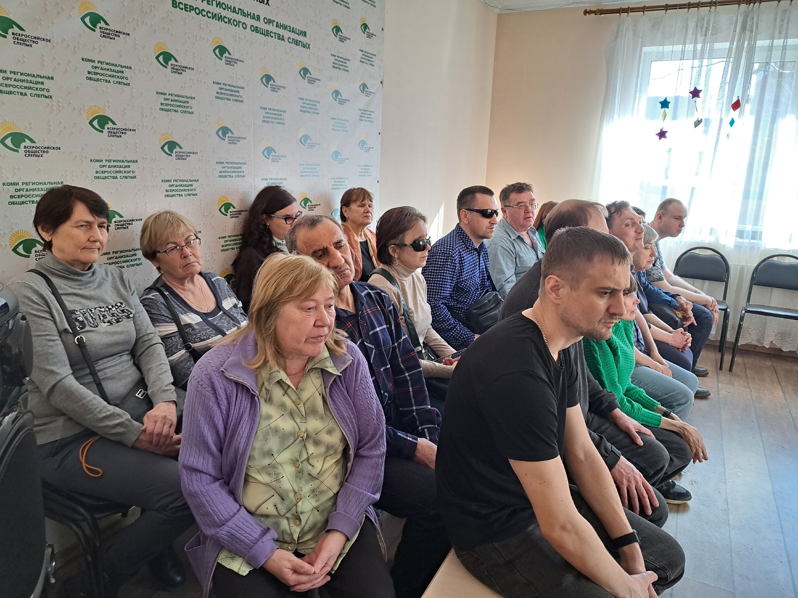 Зрители концерта сидят в зале, некоторые в темных очках