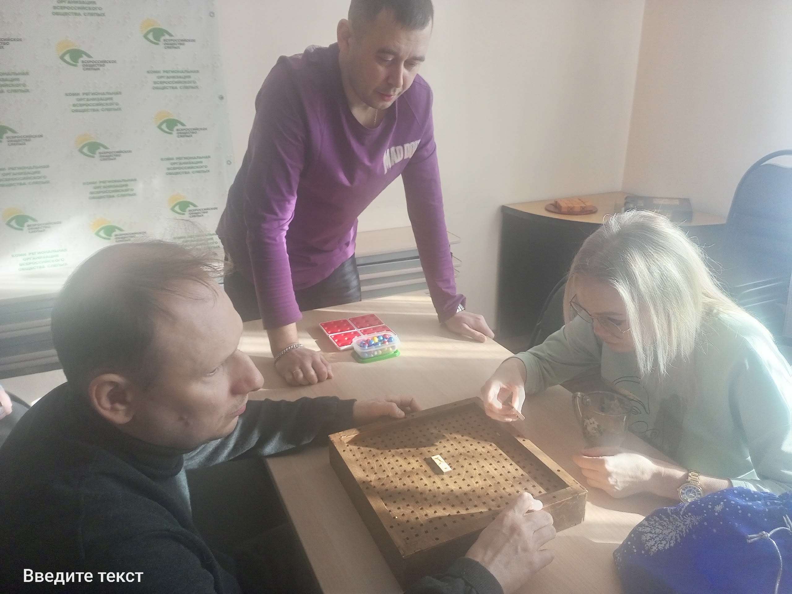 Трое людей играют в настольную игру