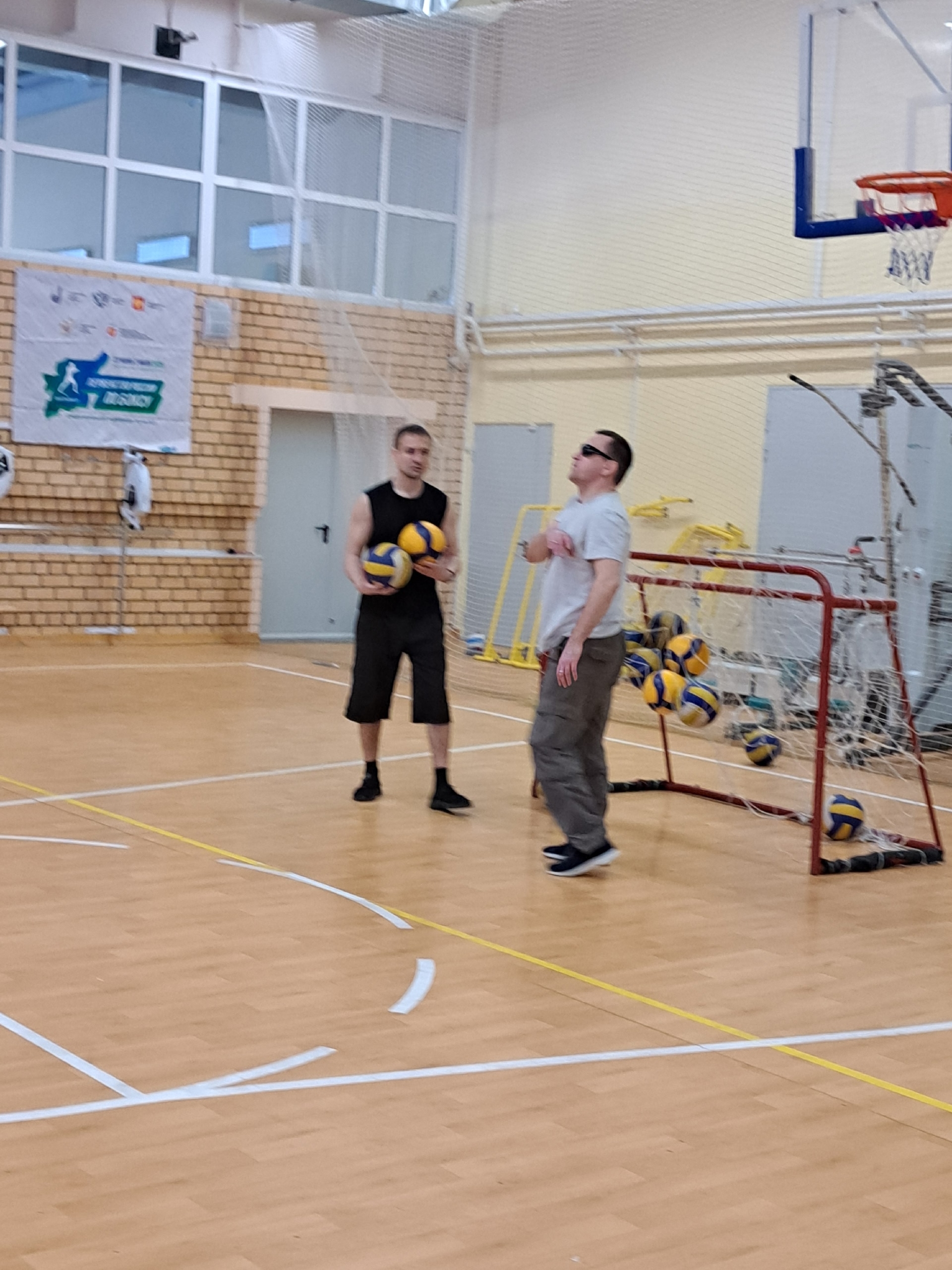 Два мужчины с волейбольными мячами на тренировке
