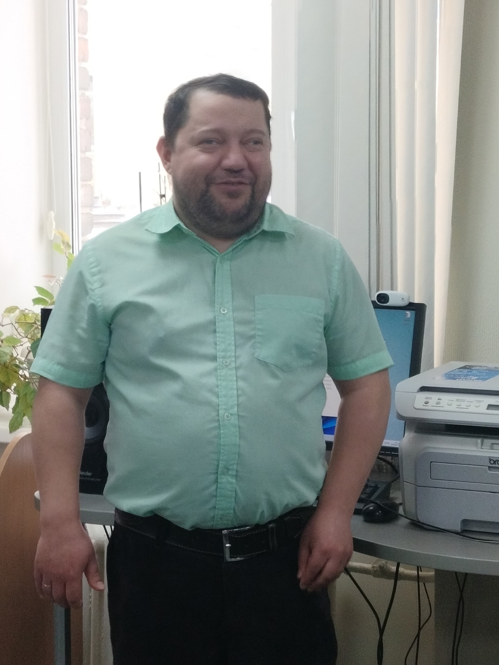Иван Ефимов, сотрудник библиотеки, стоит и улыбается