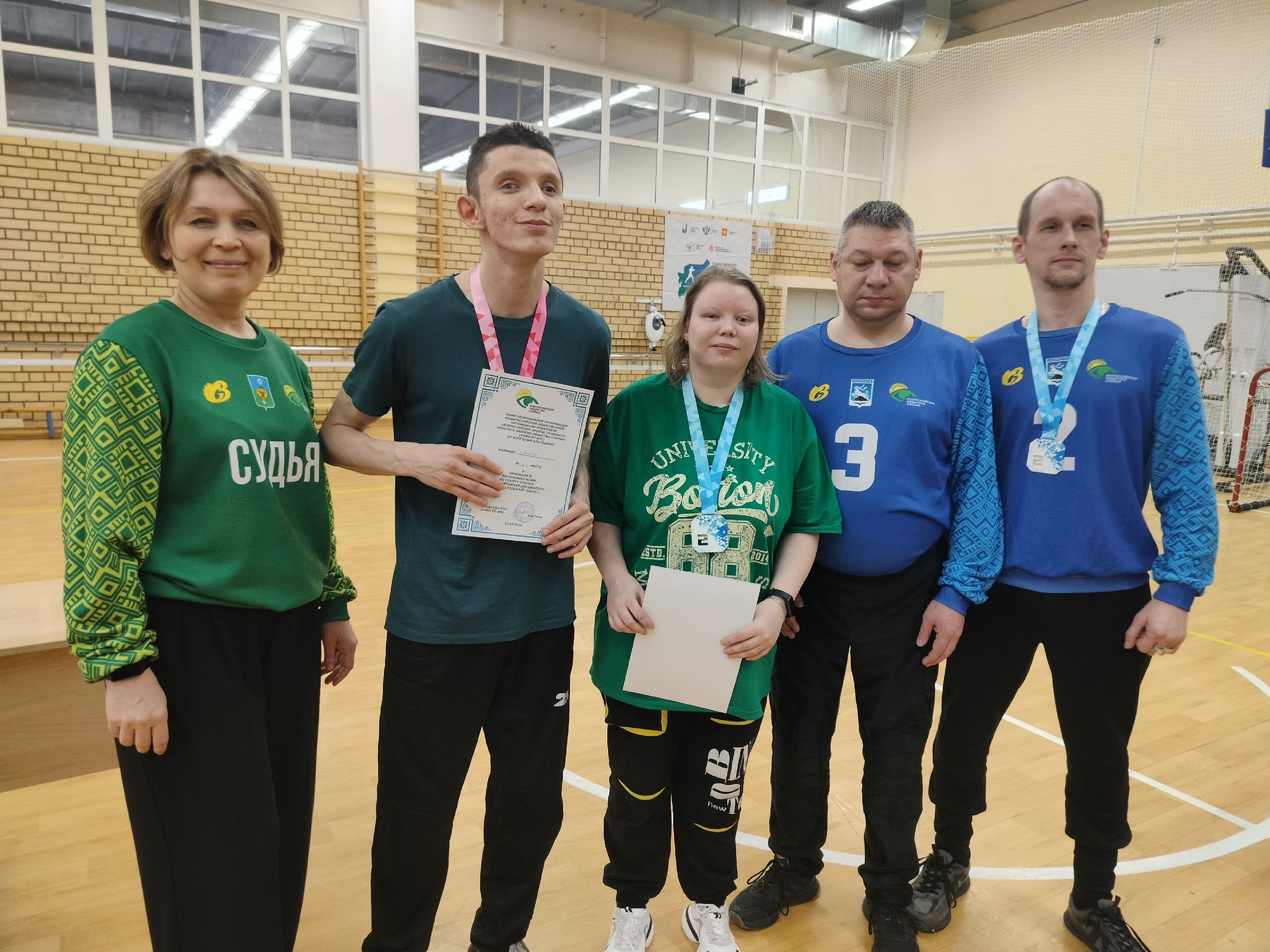 Группа спортсменов и судья с наградами и сертификатами