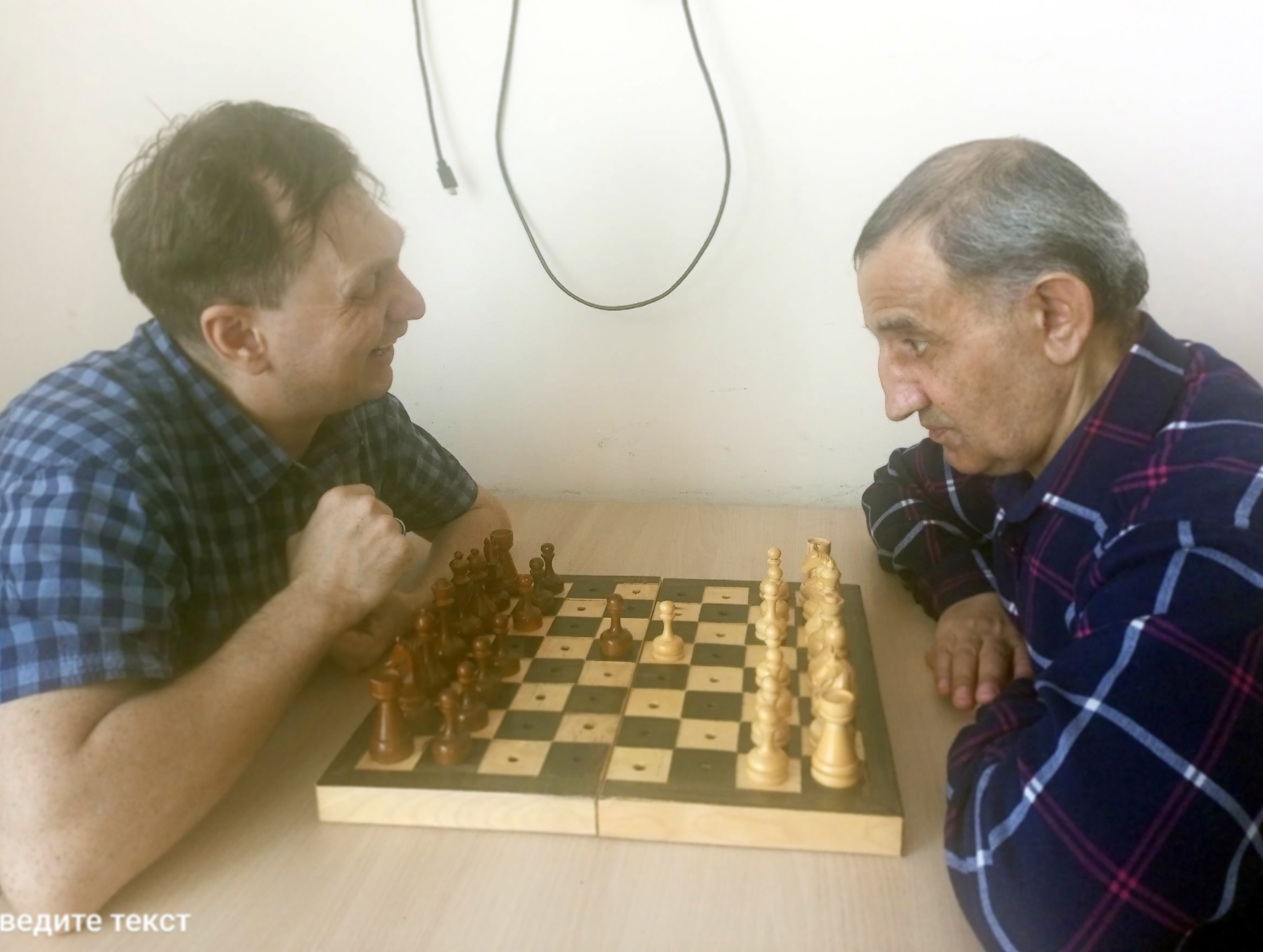 Мужчины играют в шахматы за столом
