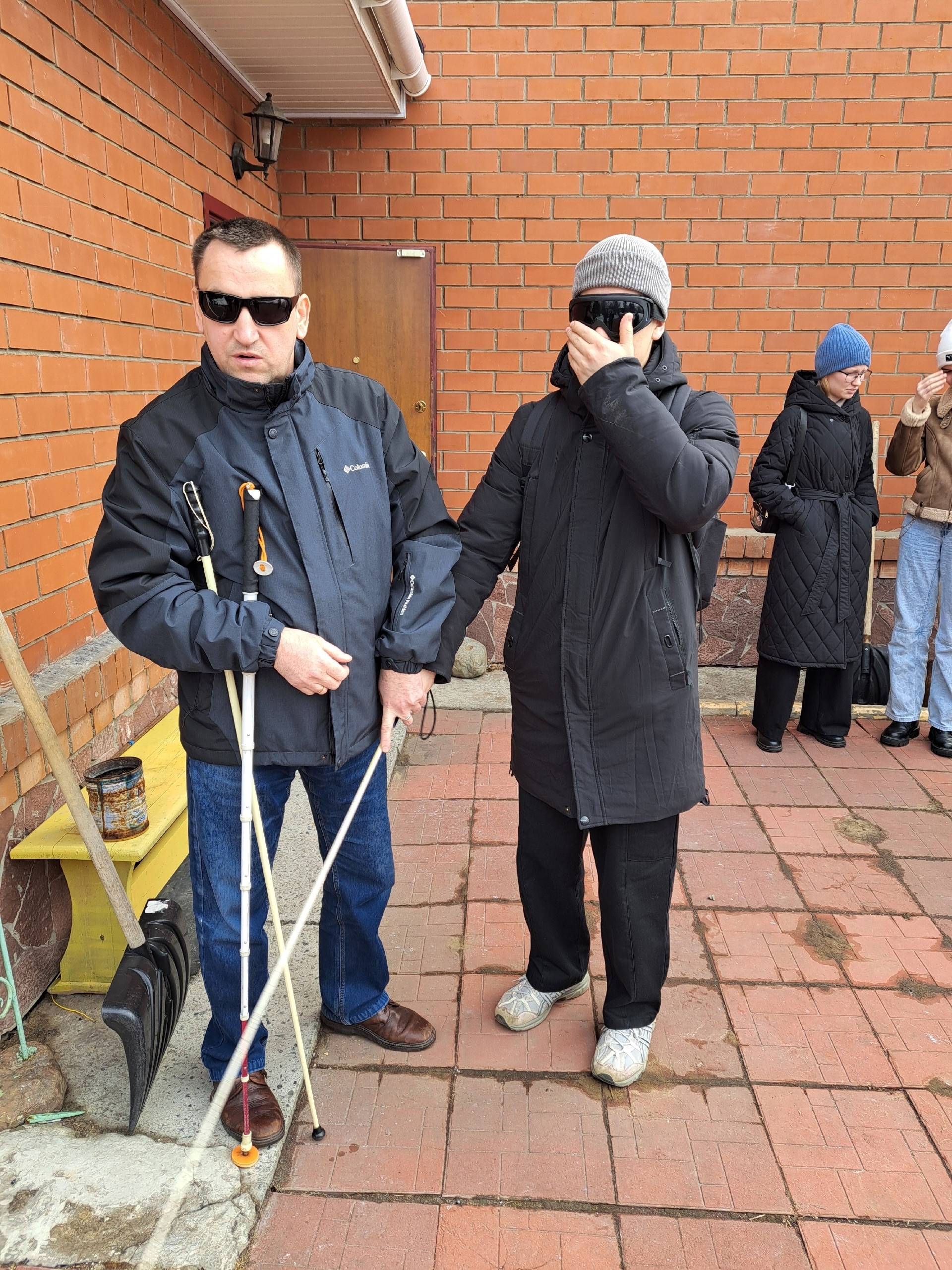 Мужчина с несколькими тростями рядом со студентом
