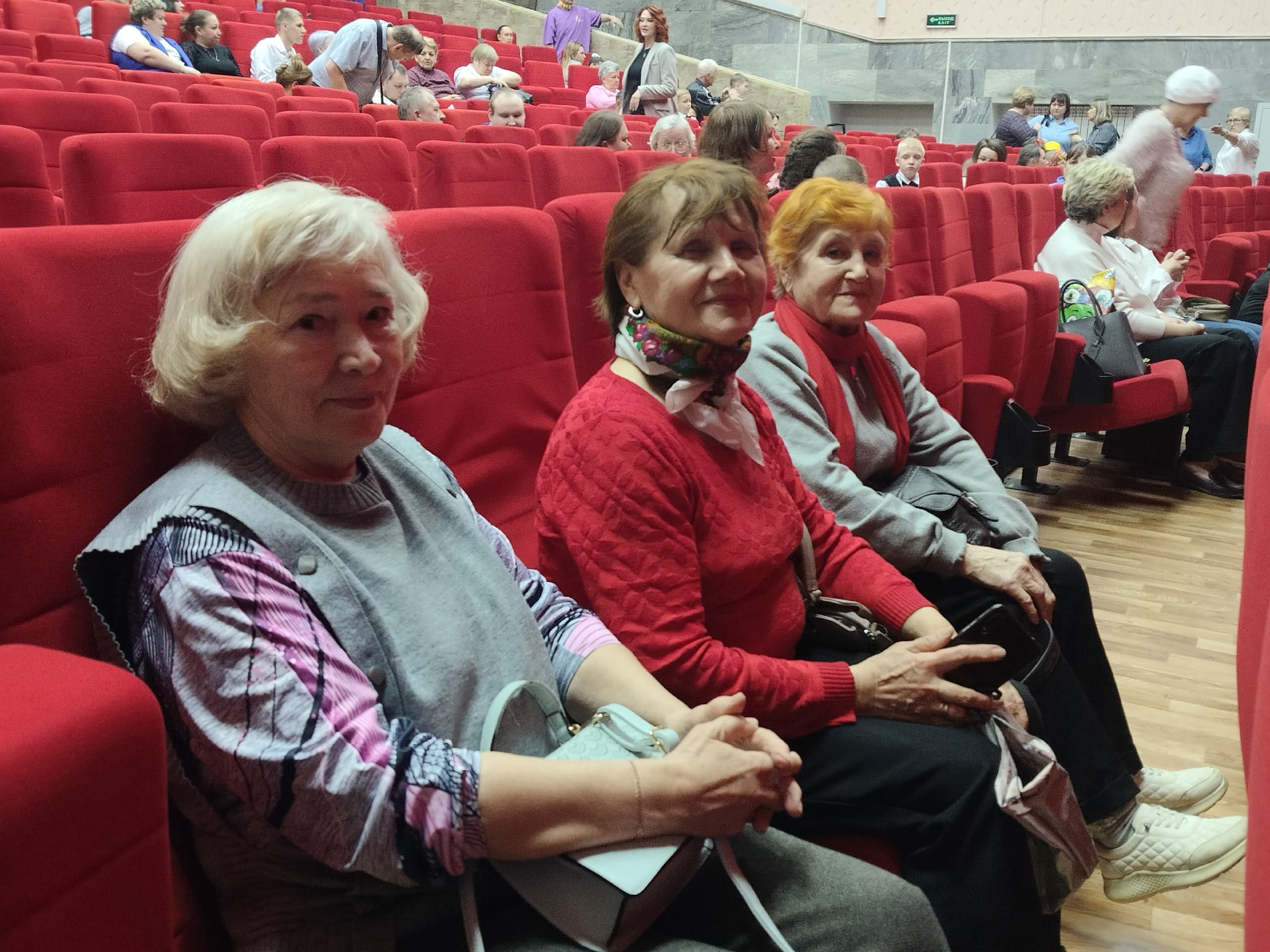 Три женщины в красных креслах зала