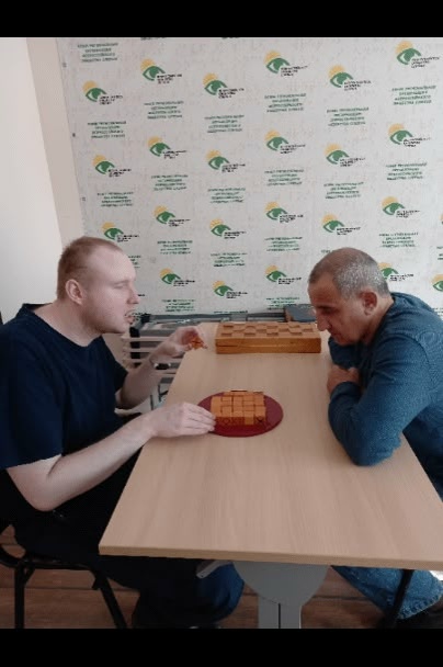 Двое мужчин играют в настольную игру с деревянными блоками