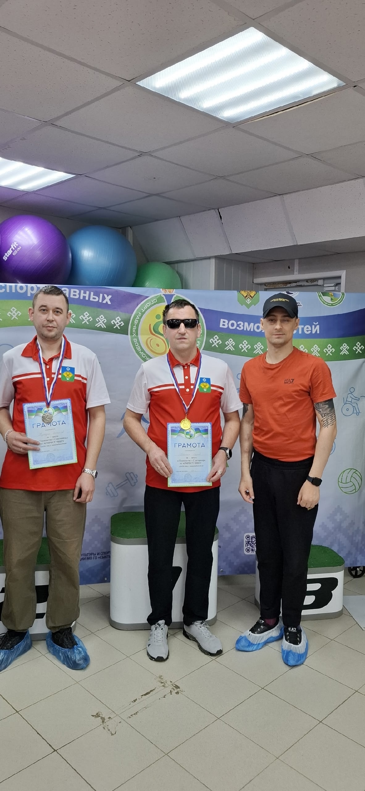 Трое мужчин с наградами, один в темных очках