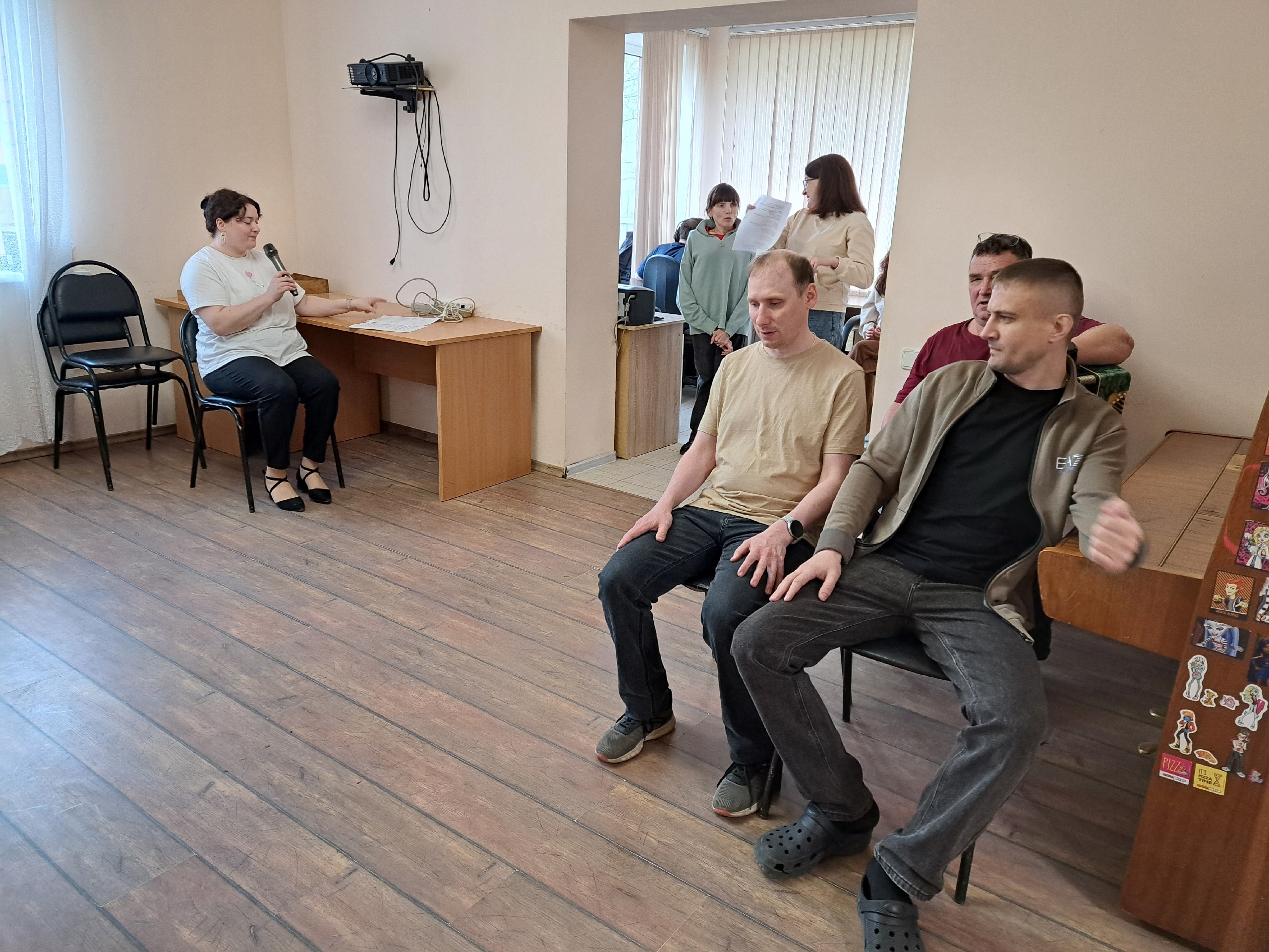 Женщина говорит в микрофон на репетиции