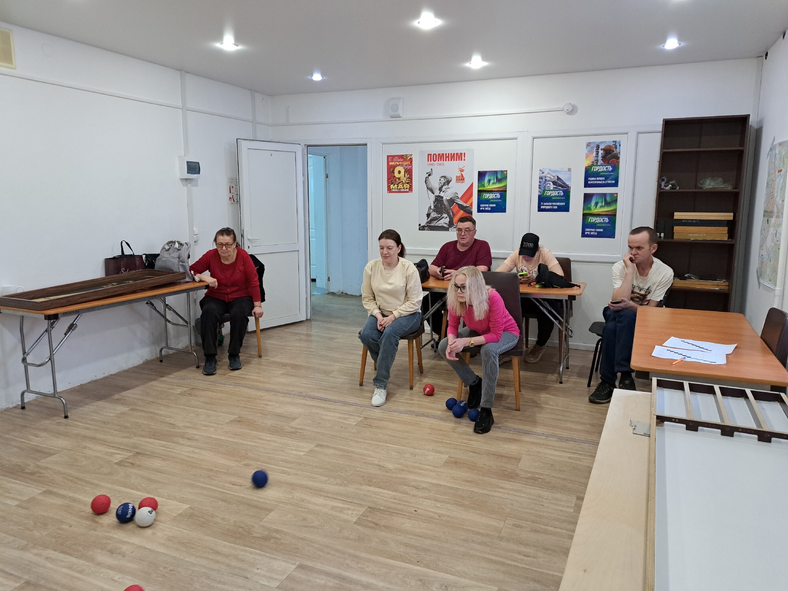 Группа людей сидит и наблюдает за игрой в бочче