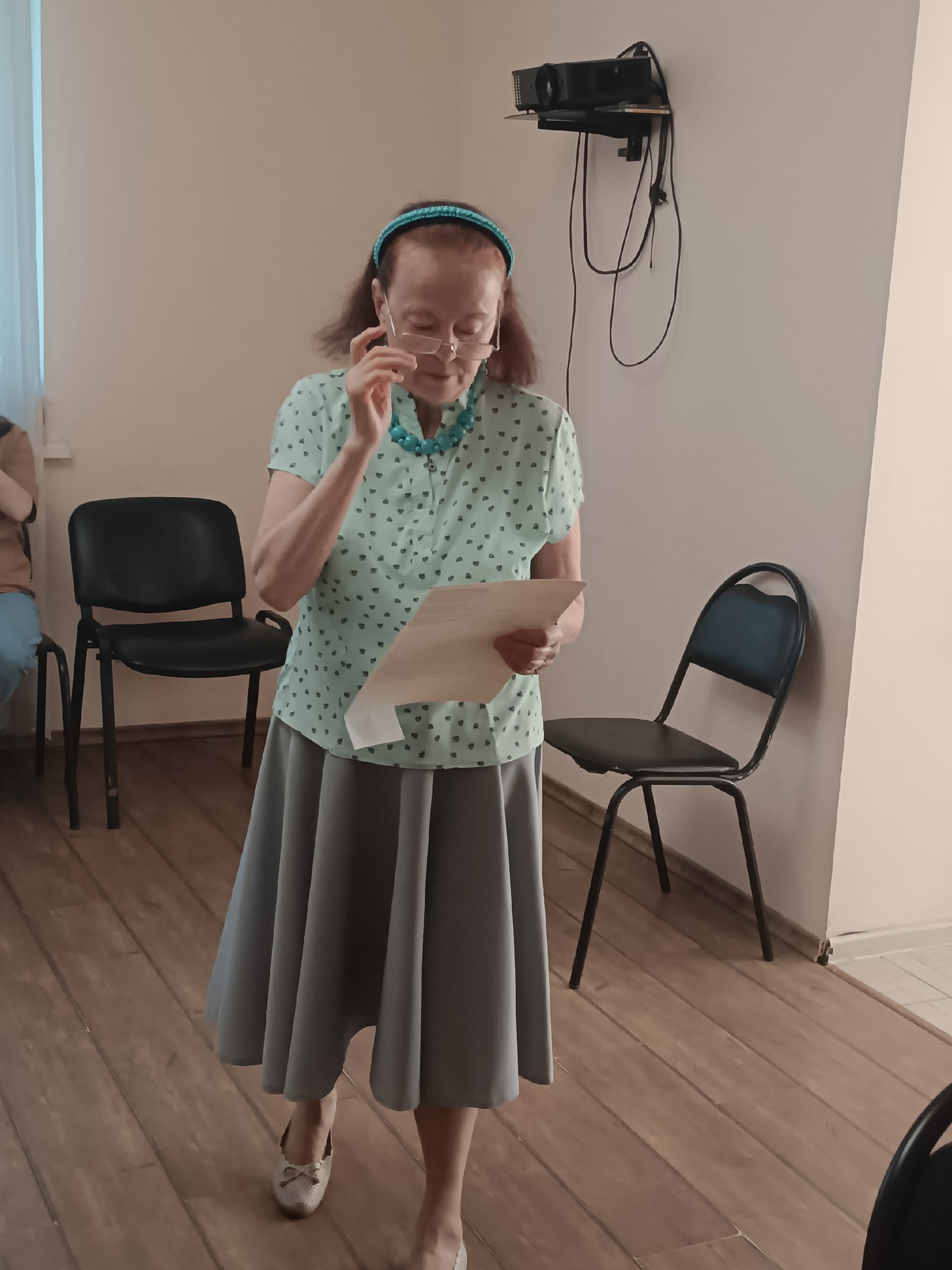 Женщина в очках читает текст с листа