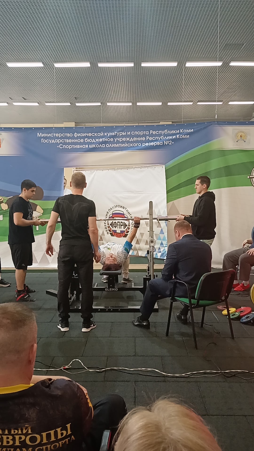 Спортсмен выполняет жим штанги лежа во время соревнований