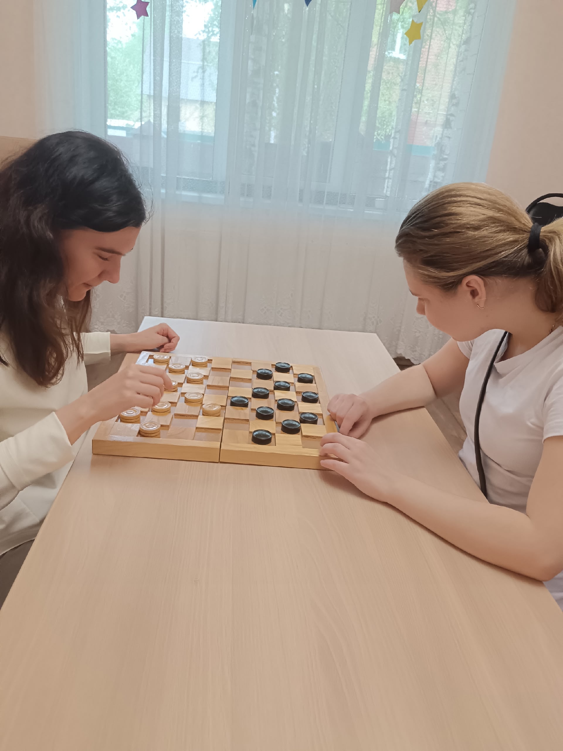 Две девушки играют в шашки