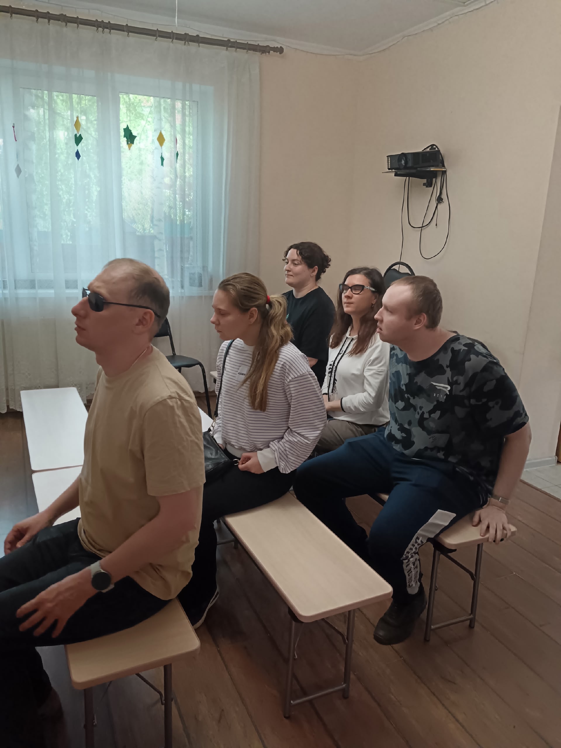 Слушатели сидят на скамейках во время встречи