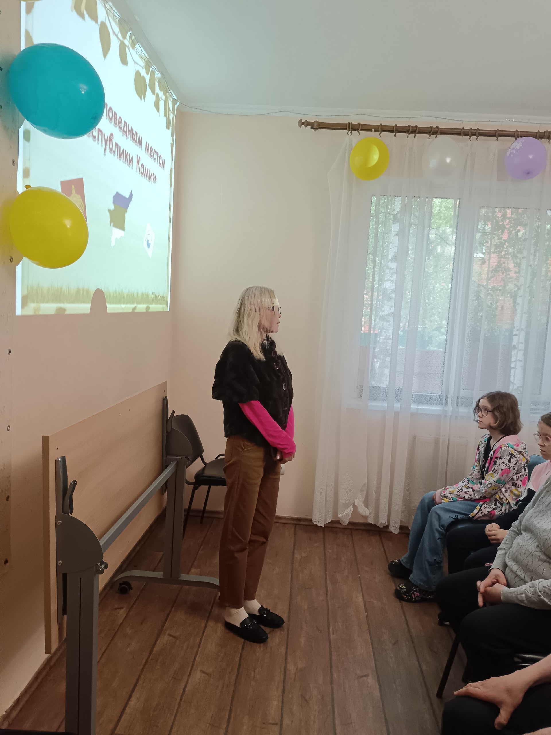 Женщина проводит презентацию перед аудиторией в светлом помещении
