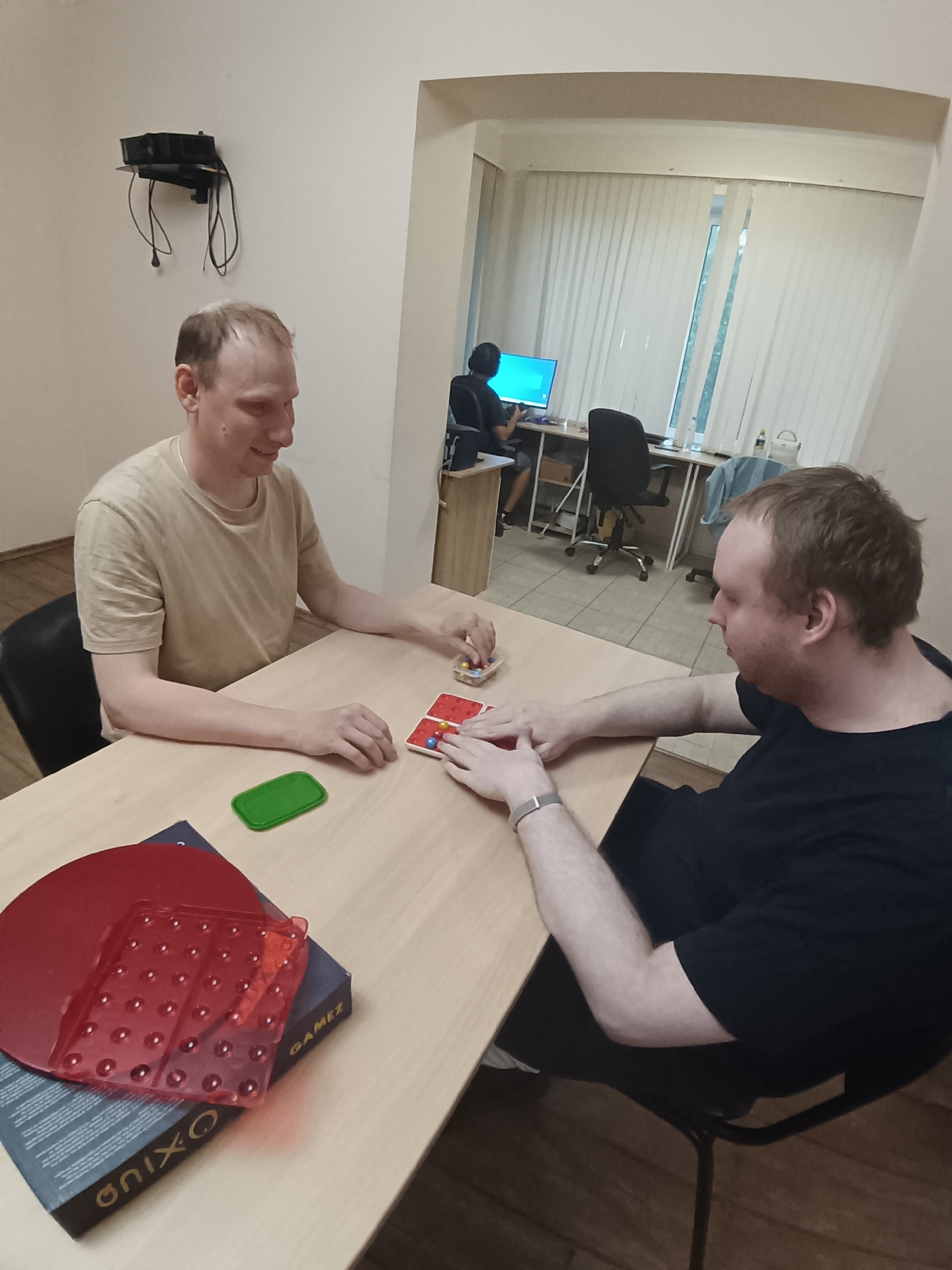 Двое мужчин играют в настольную игру с фишками