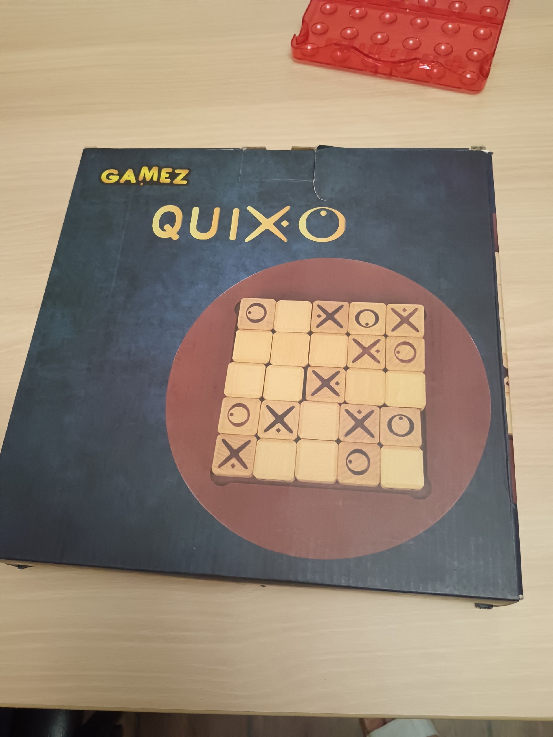 Коробка с настольной игрой Quixo на столе