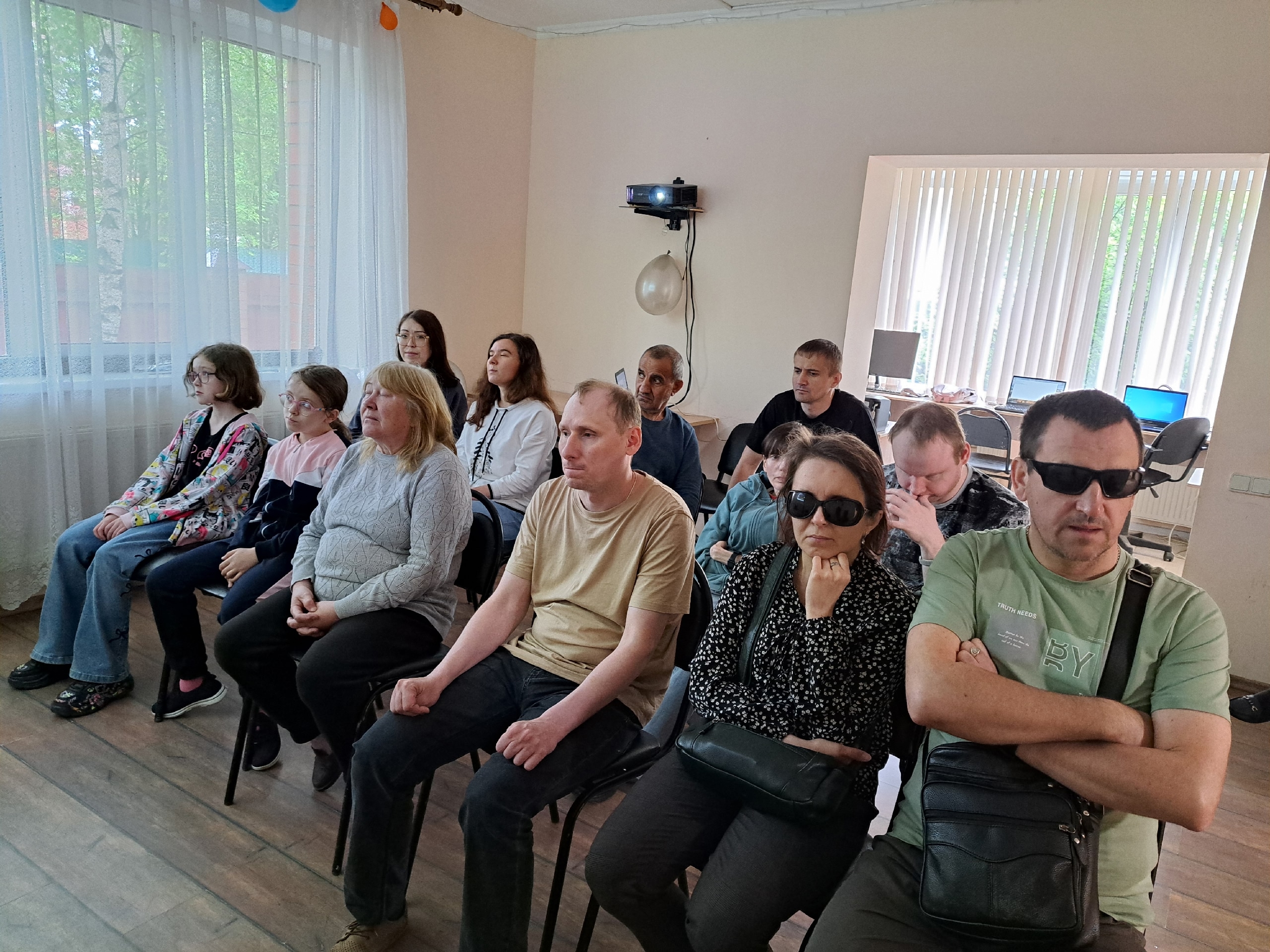 Зрители сидят на стульях и внимательно смотрят фильм в зале