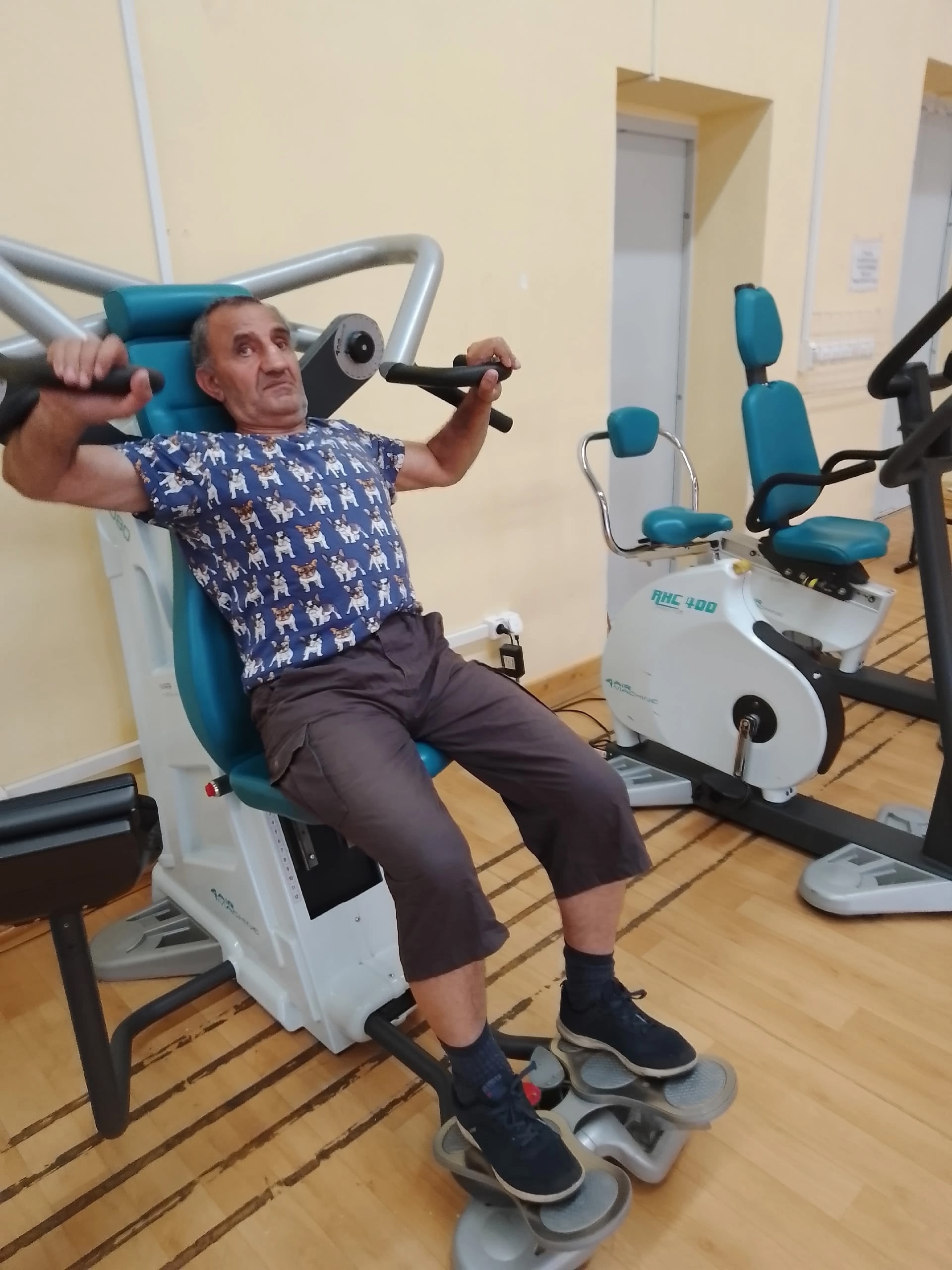 Мужчина выполняет упражнения на тренажере для рук в спортивном зале