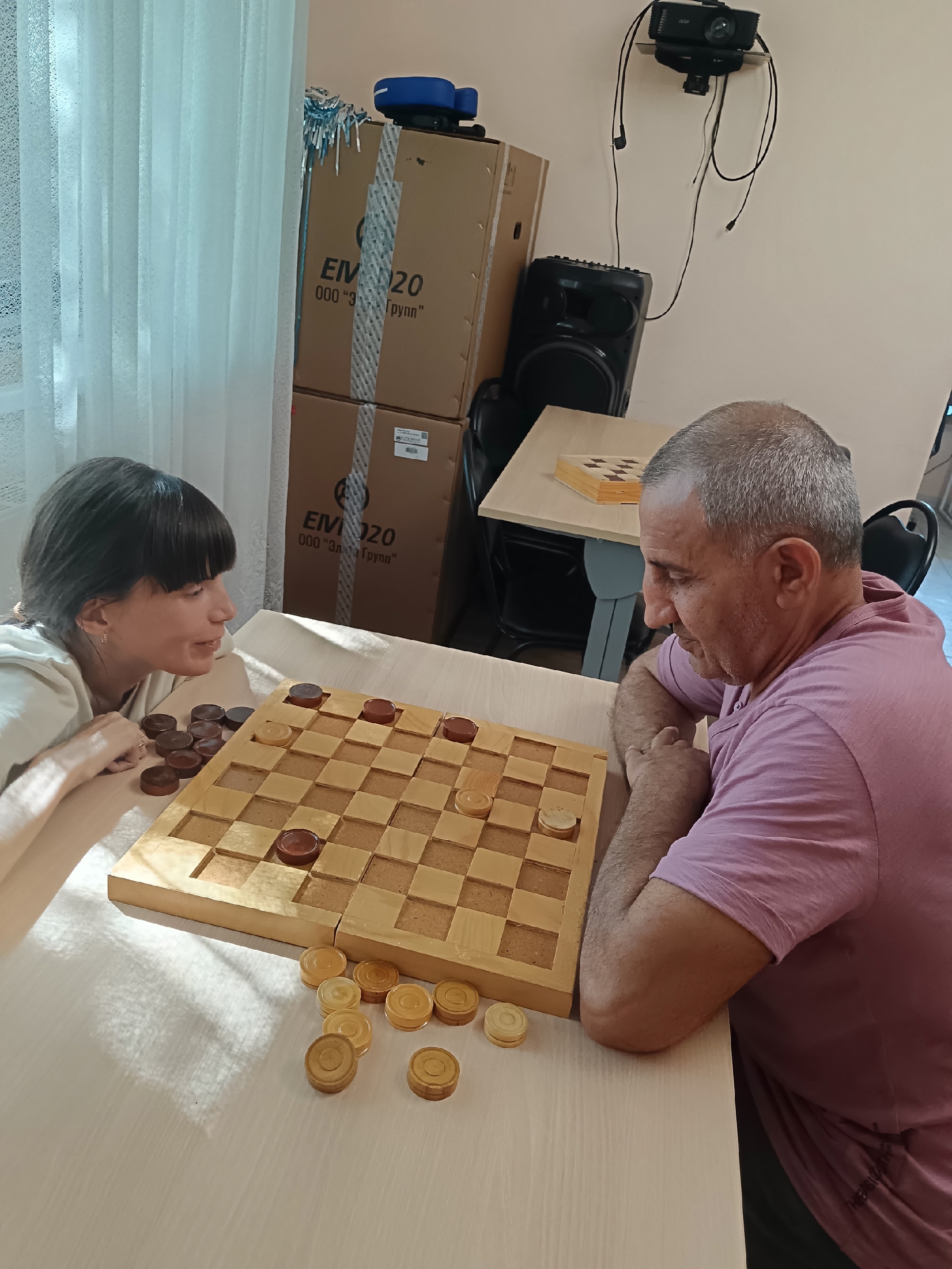 Крупный план игры в шашки между мужчиной и молодой женщиной