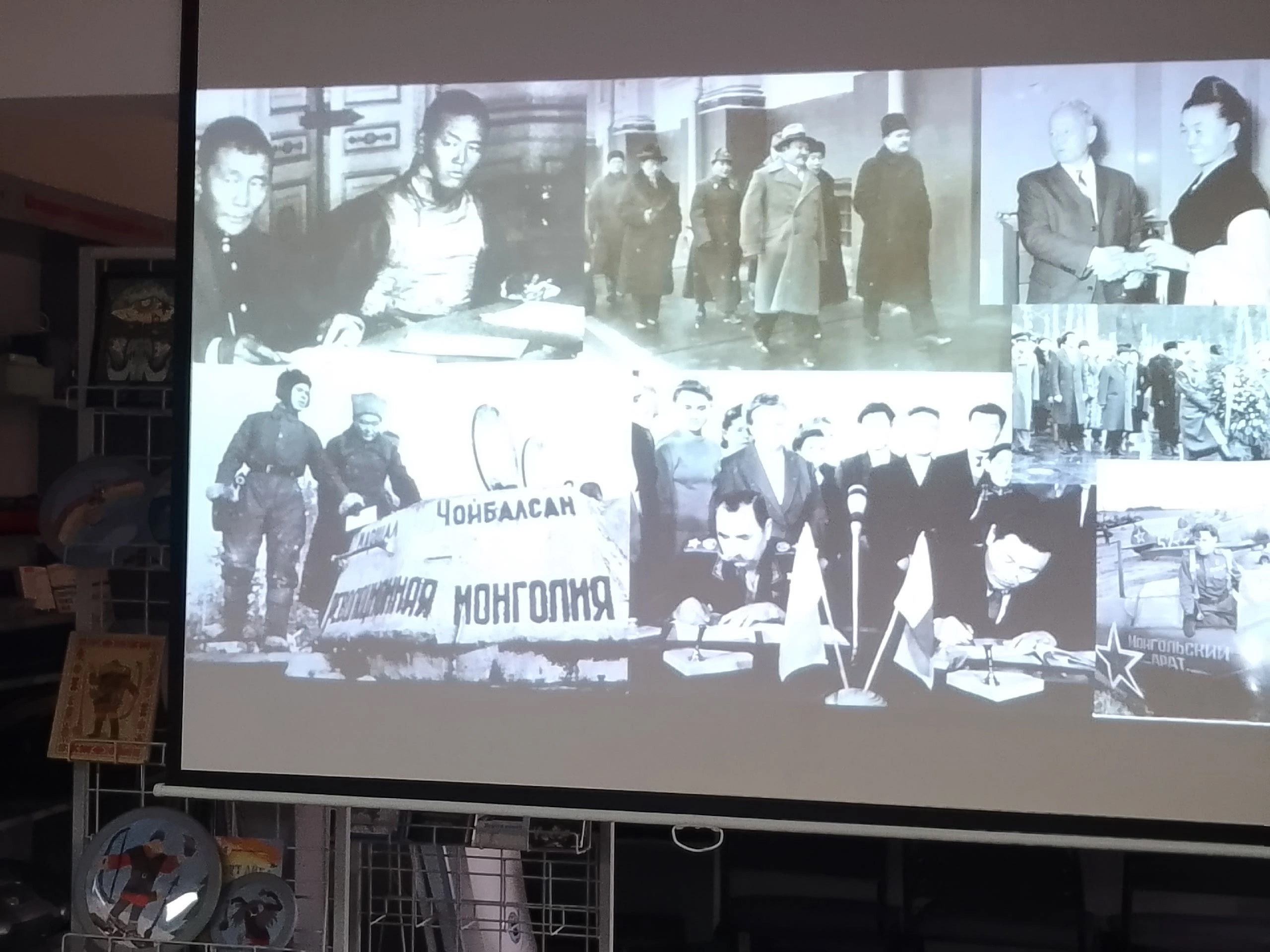 Исторические черно-белые фотографии Монголии на экране проектора во время презентации