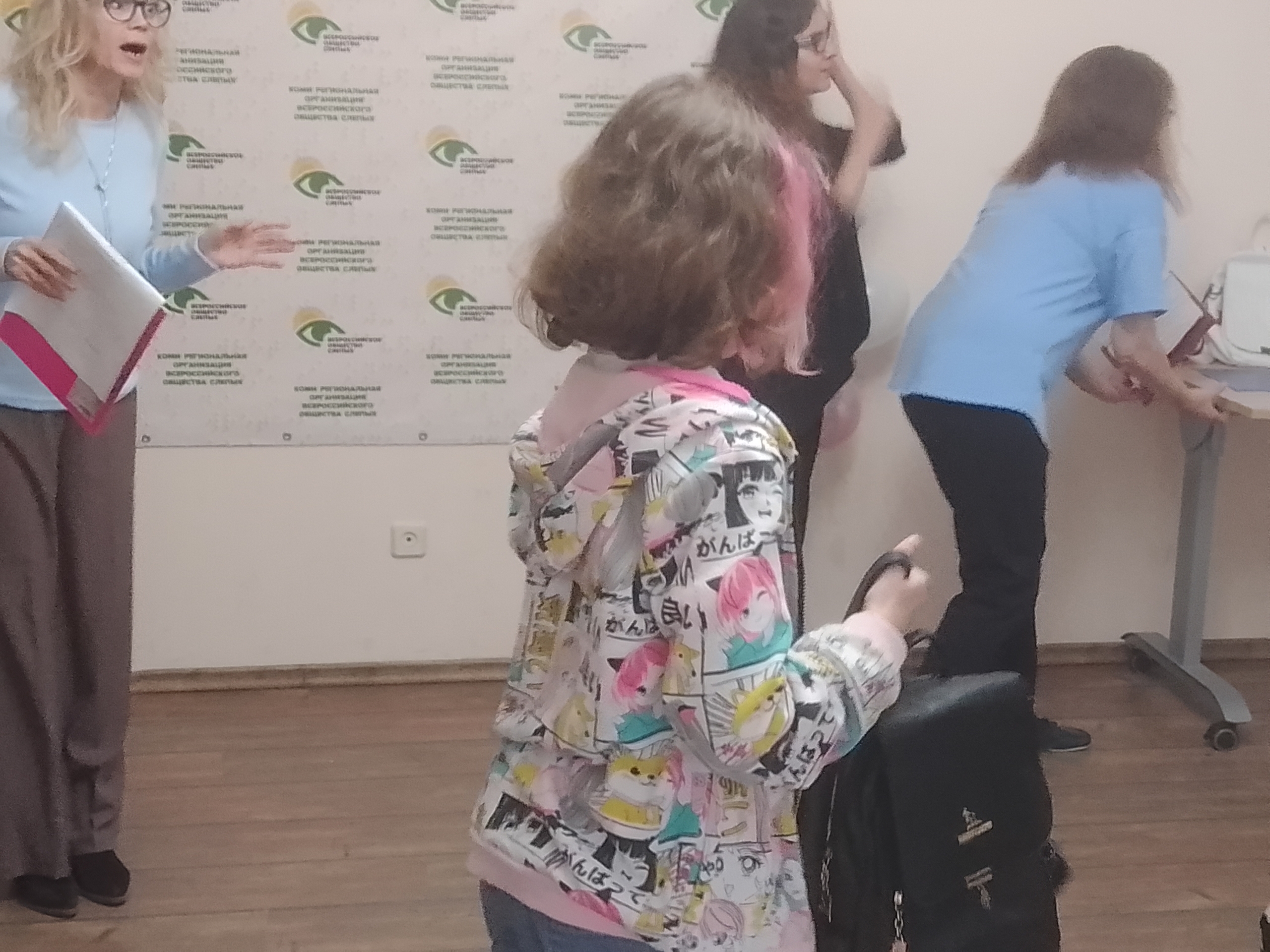 Девочка в толстовке с принтом аниме стоит в помещении