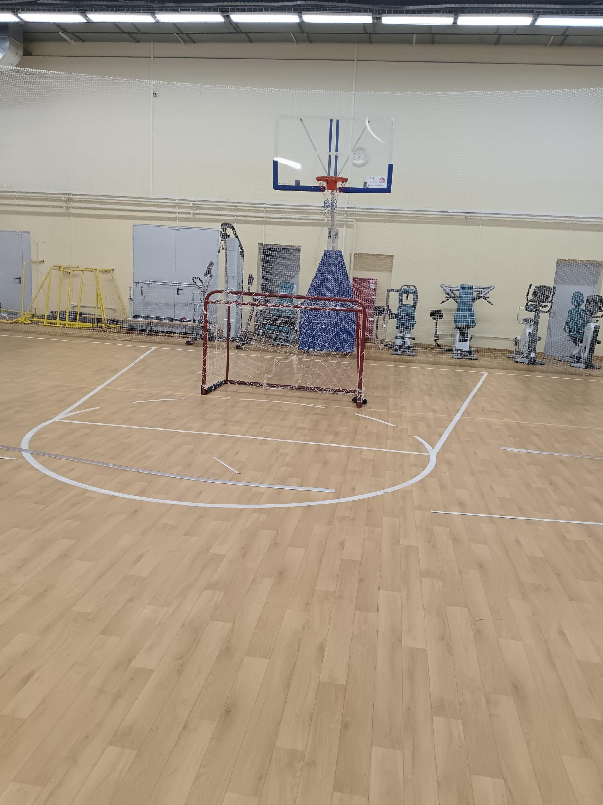 Маленькие спортивные ворота с сеткой установлены на разметке в пустом игровом зале