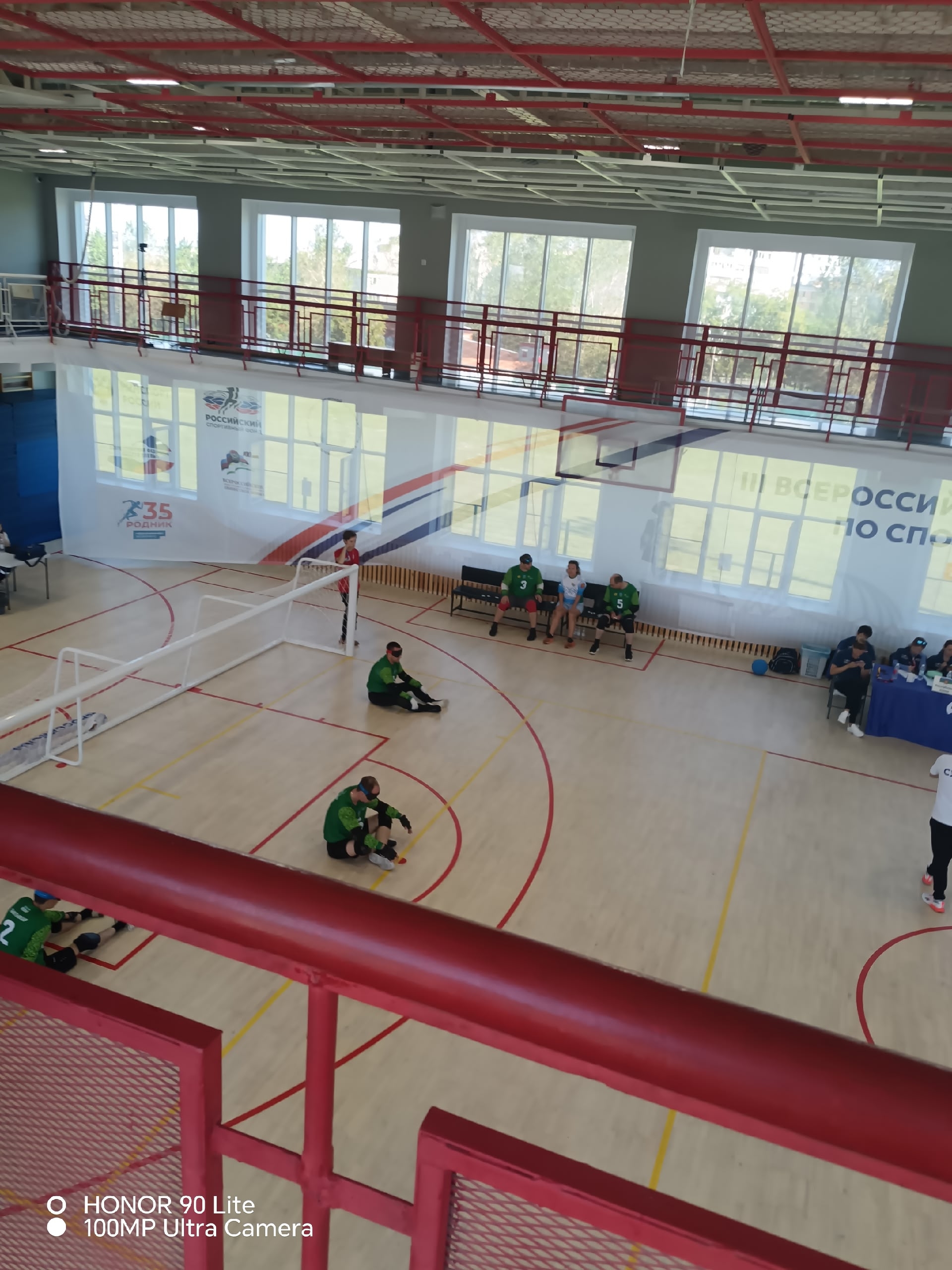 Спортсмены в зеленой форме на площадке для голбола во время подготовки к игре