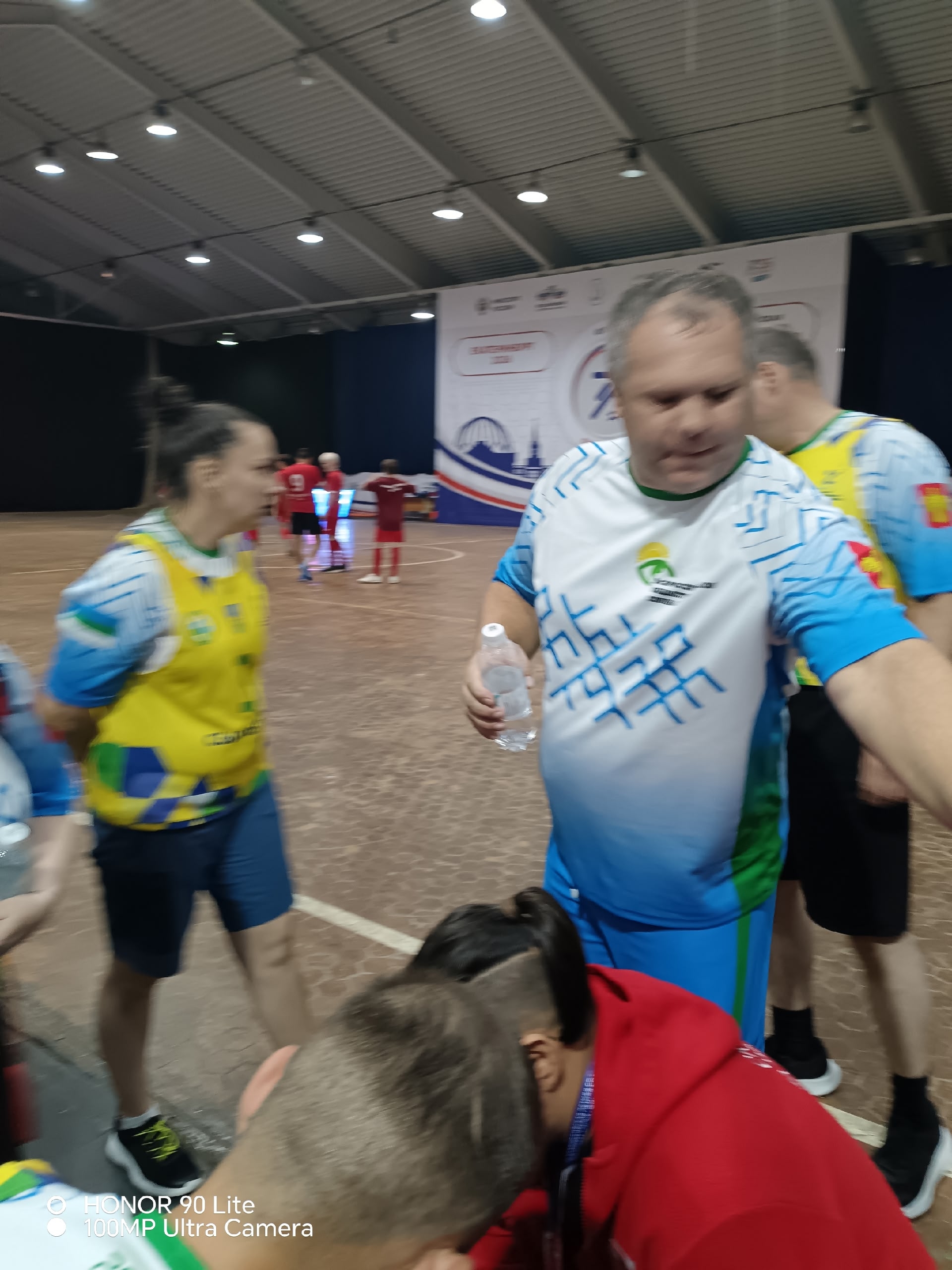 Спортсмены в спортивной экипировке общаются во время перерыва в зале