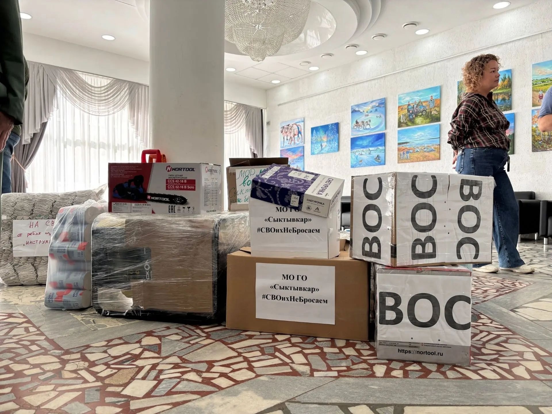 Коробки с гуманитарной помощью и надписями ВОС сложены на полу