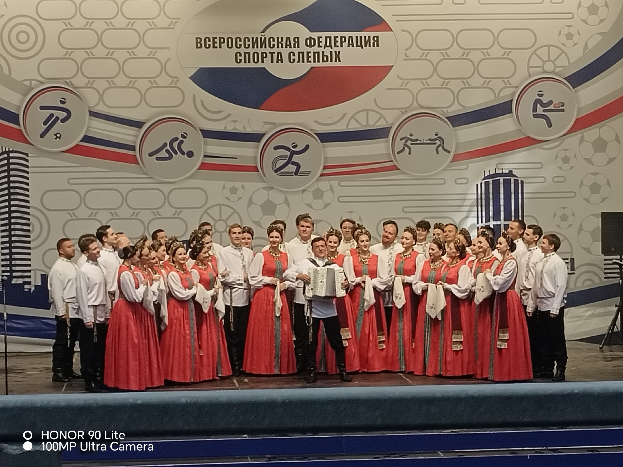 Выступление артистов в традиционных русских костюмах на сцене с баянистом