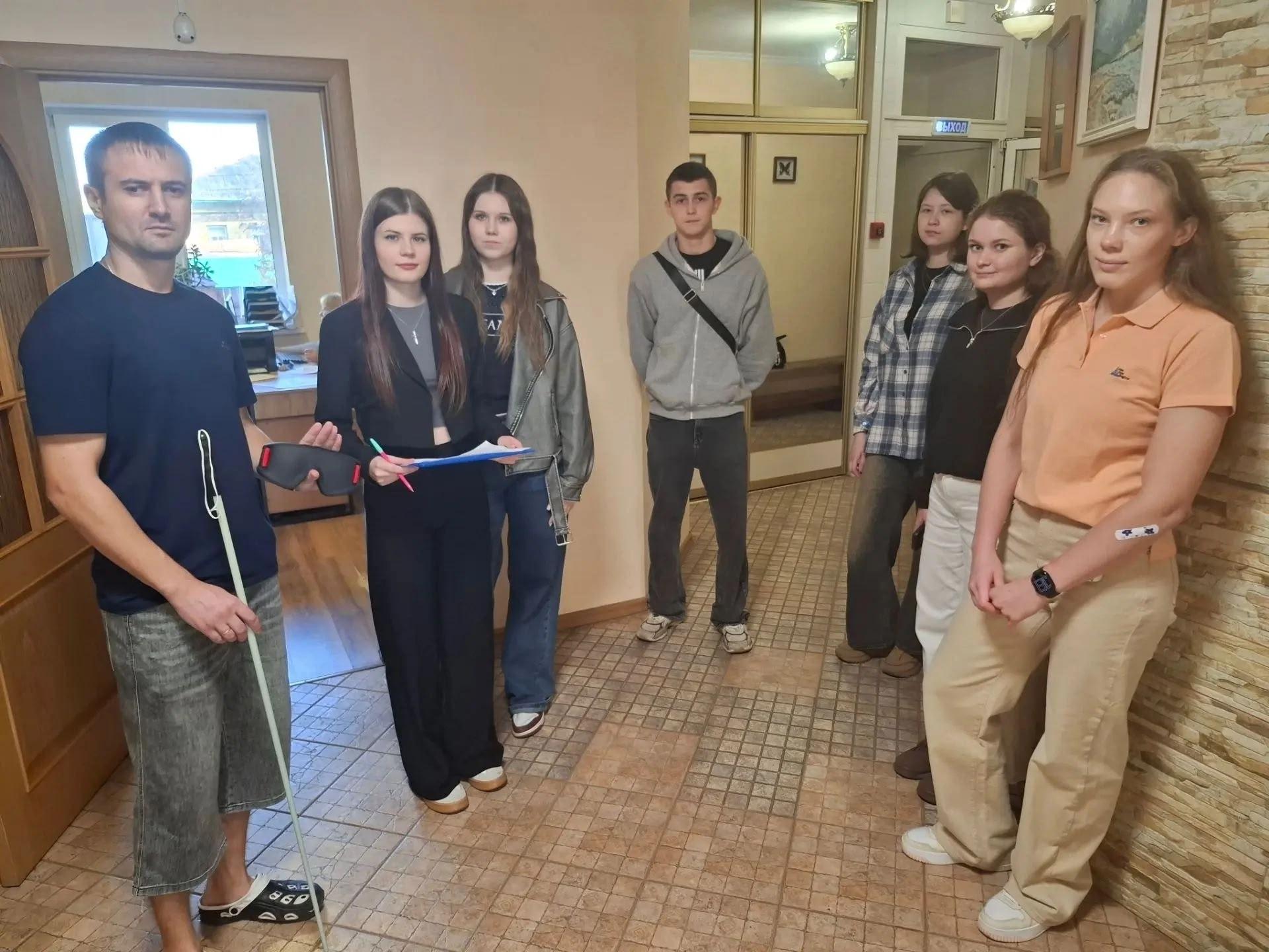 Группа студентов и участников стоит в коридоре здания