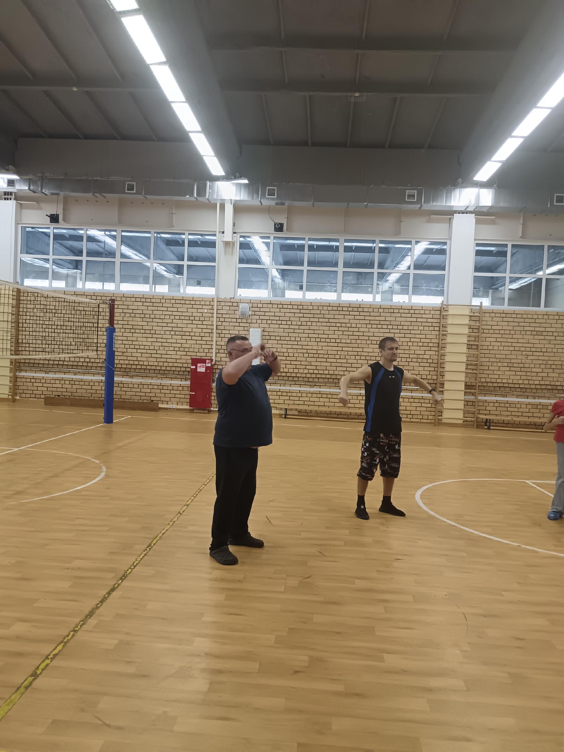 Мужчины делают разминку в зале