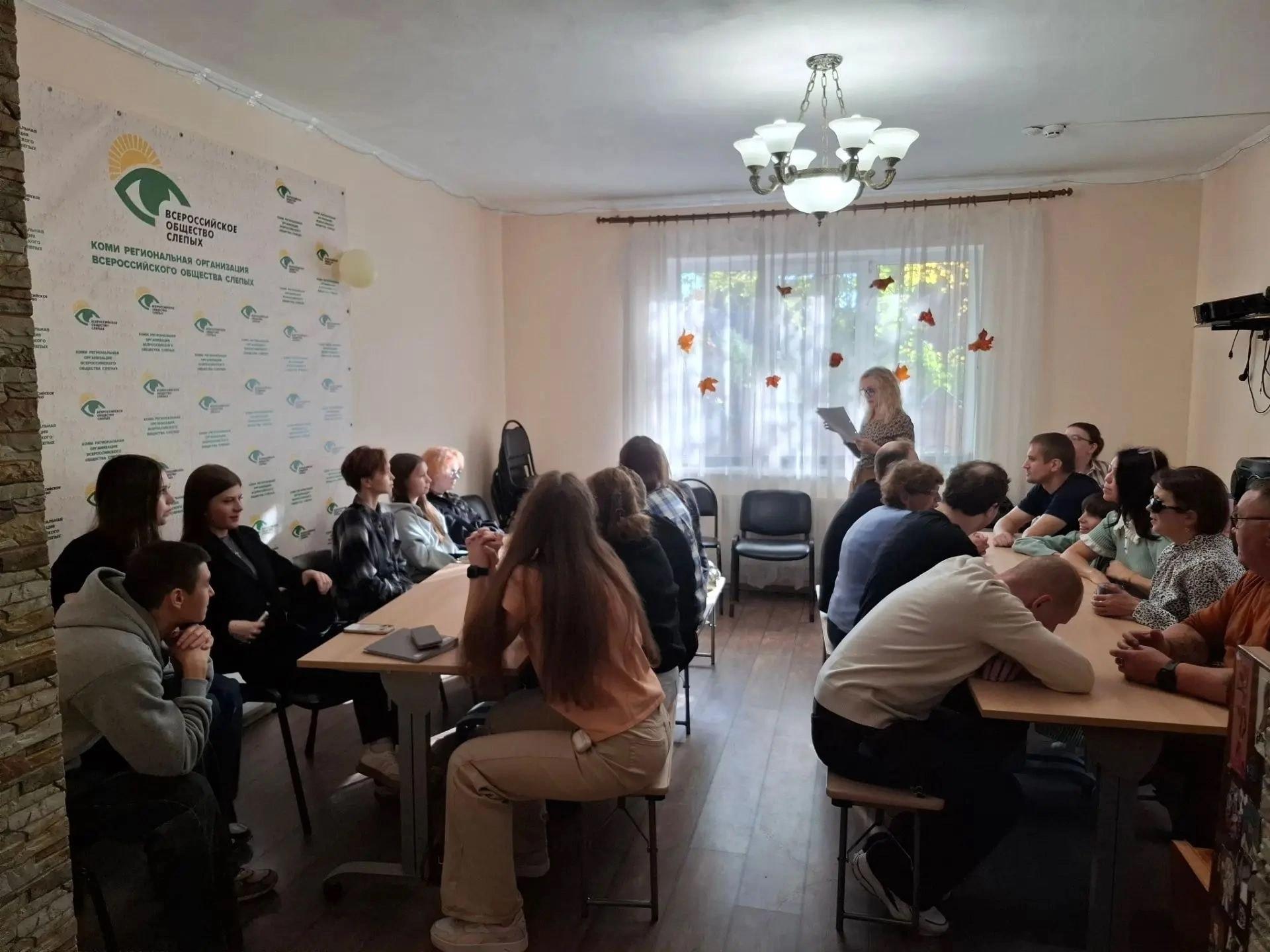 Женщина с листом бумаги ведет мероприятие в аудитории