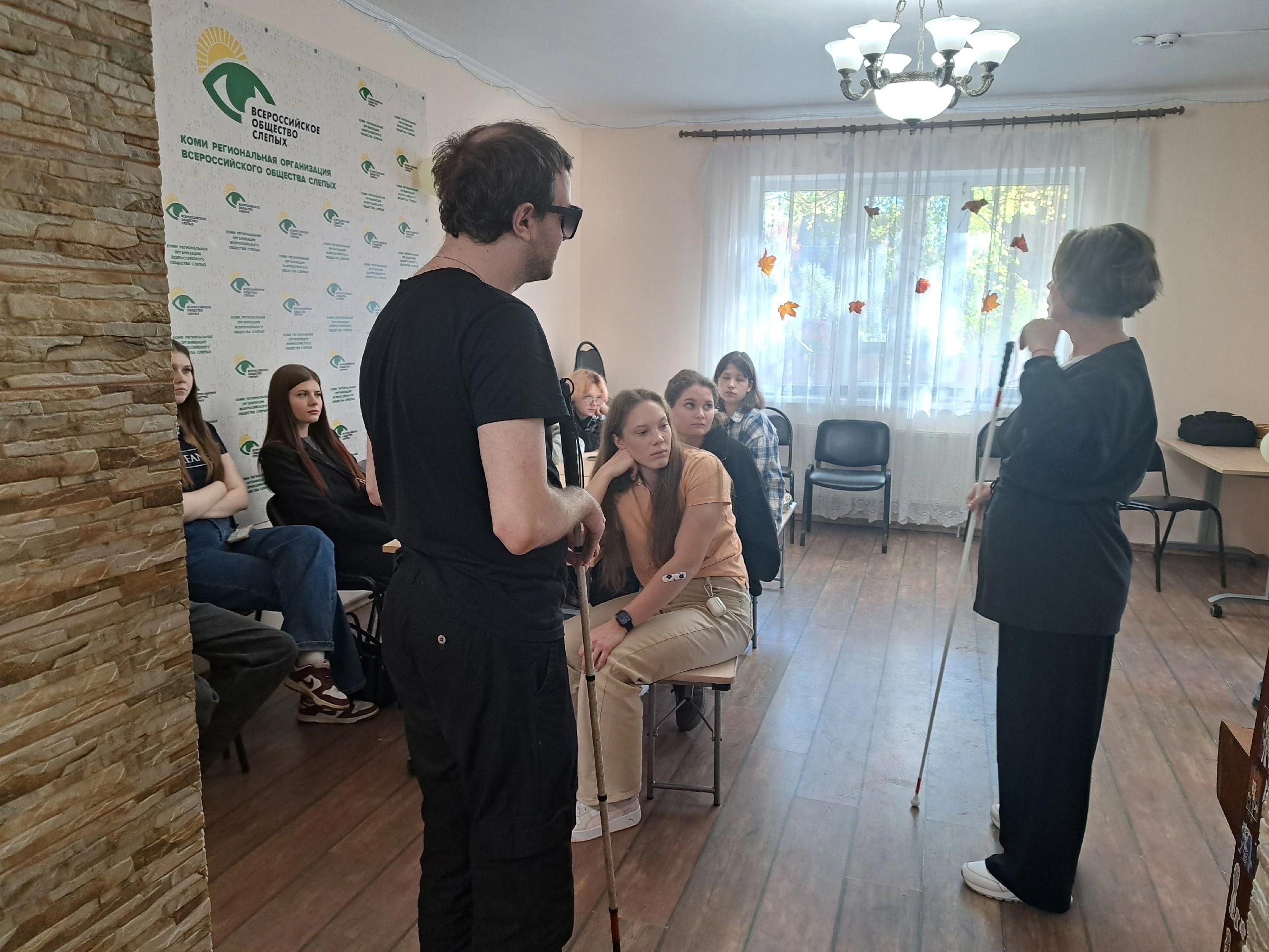 Участники тифлотроеборья с тростями общаются в комнате
