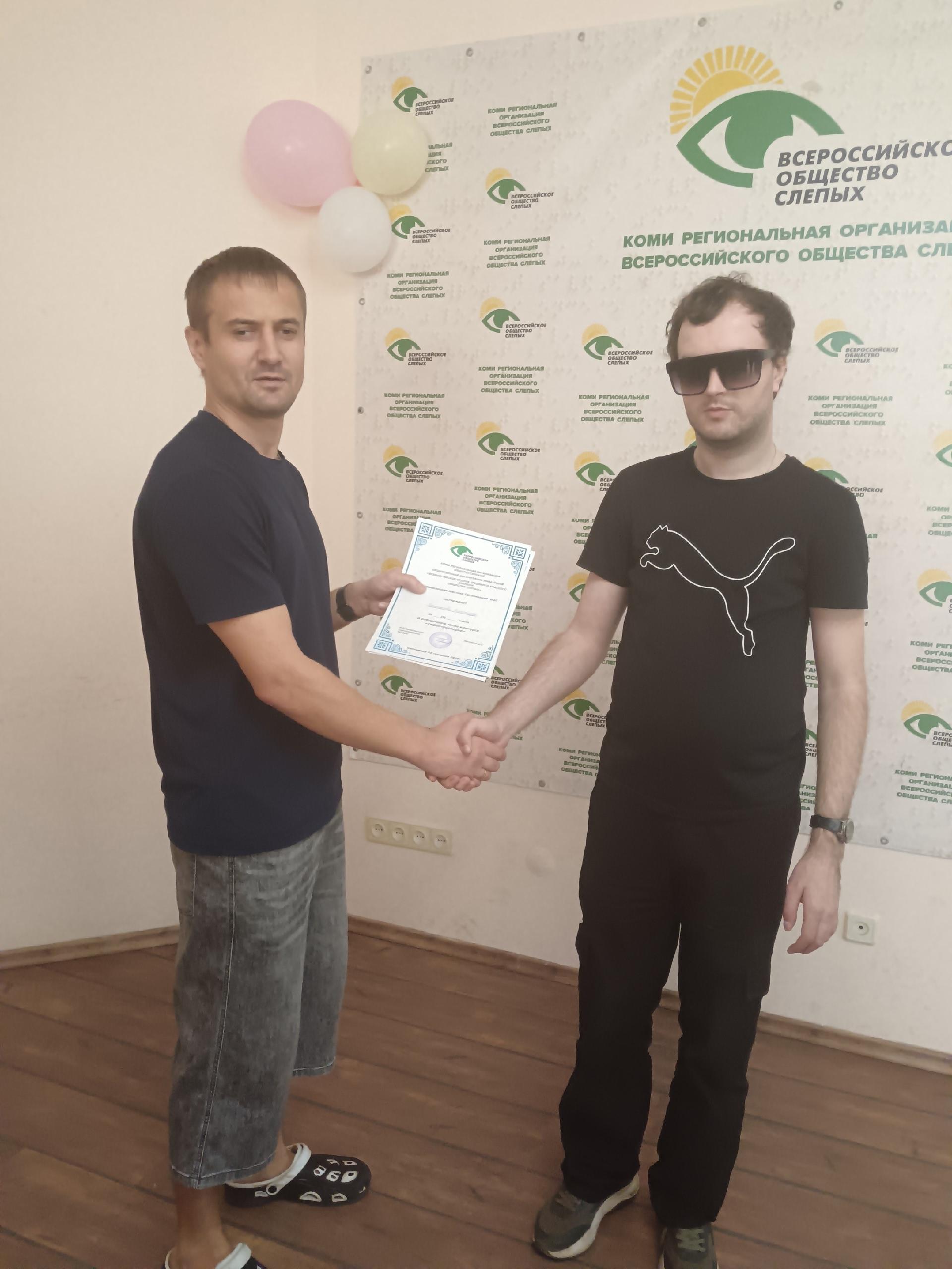 Мужчина вручает грамоту победителю конкурса Тифлотроеборье