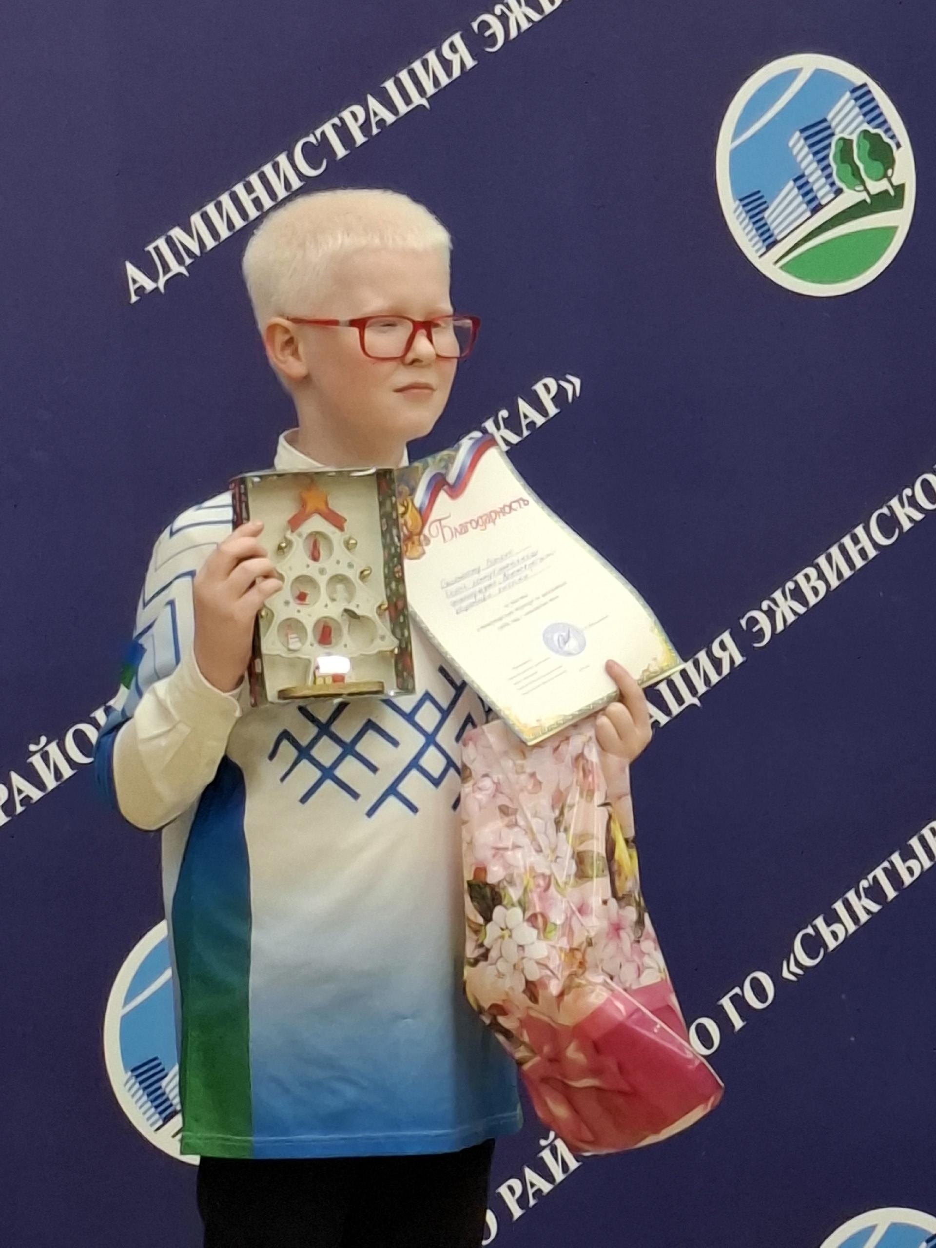 Участник шахматного турнира держит подарки и грамоту