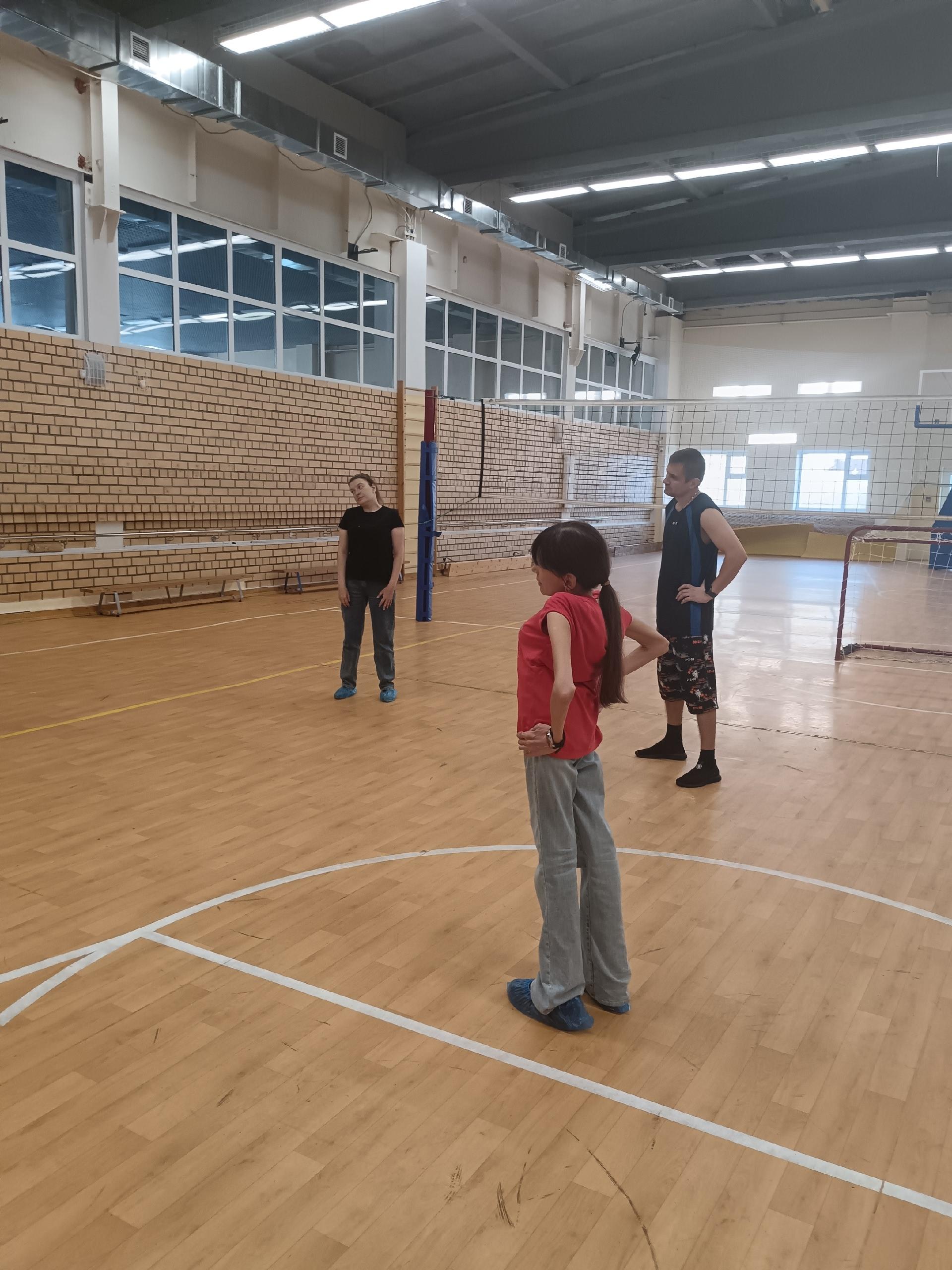 Люди стоят на волейбольной площадке