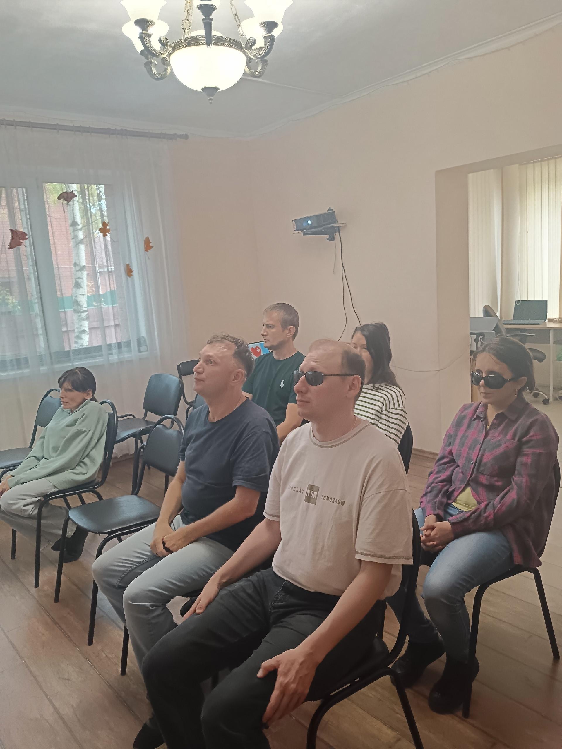 Слушатели сидят на стульях в светлой аудитории