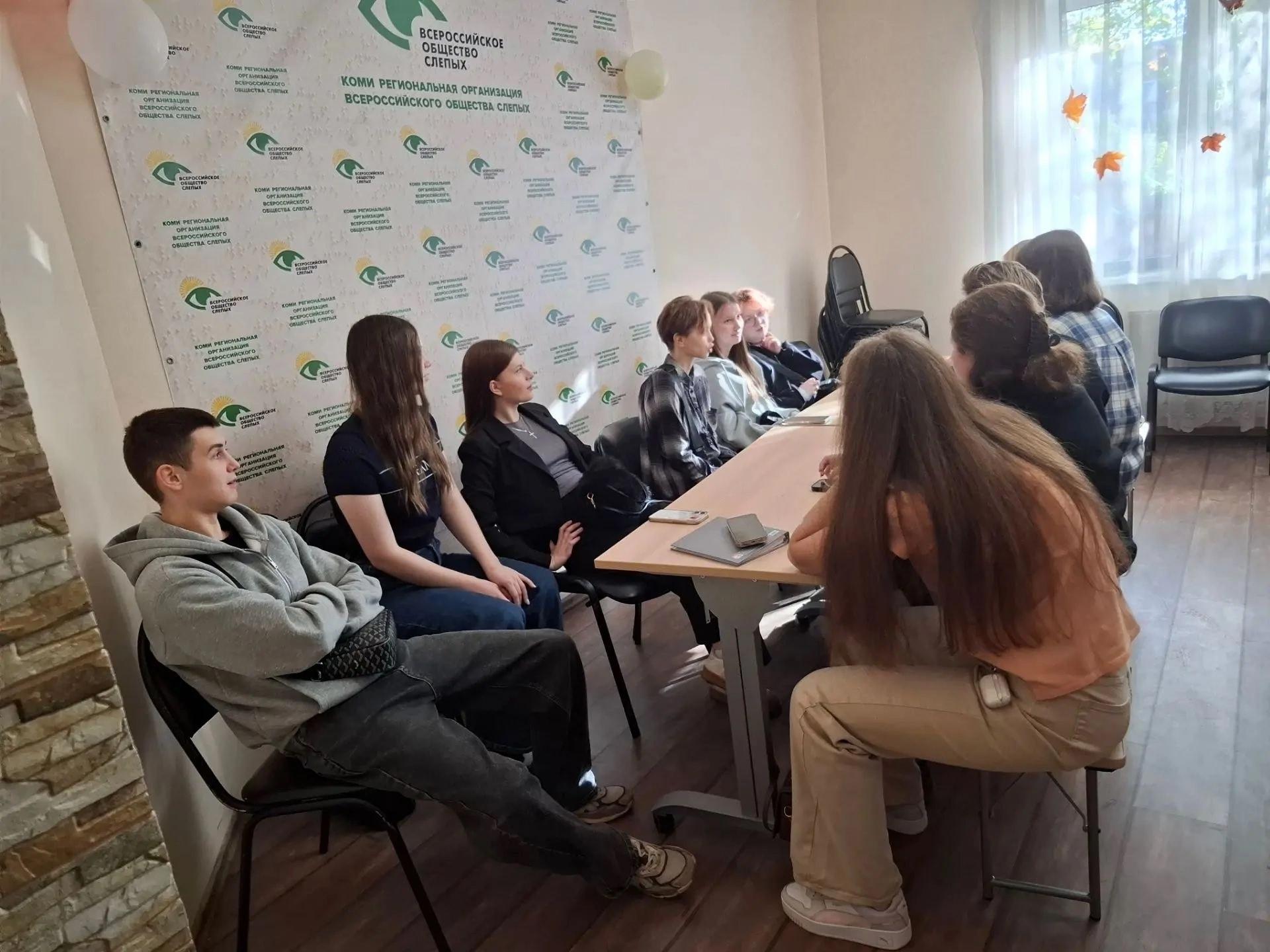 Молодые люди и девушки общаются за столом во время встречи