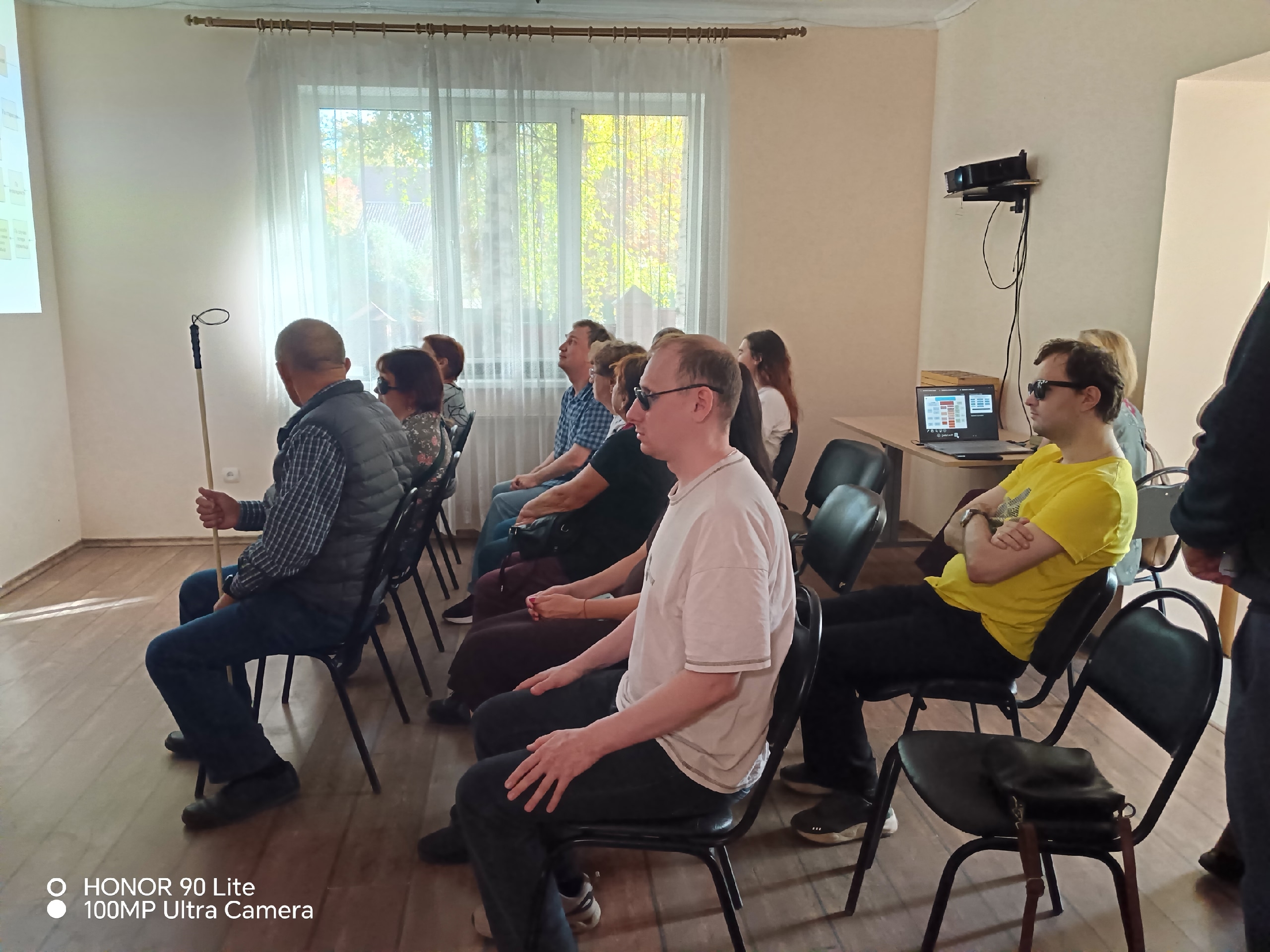 Участники встречи сидят в зале и смотрят презентацию
