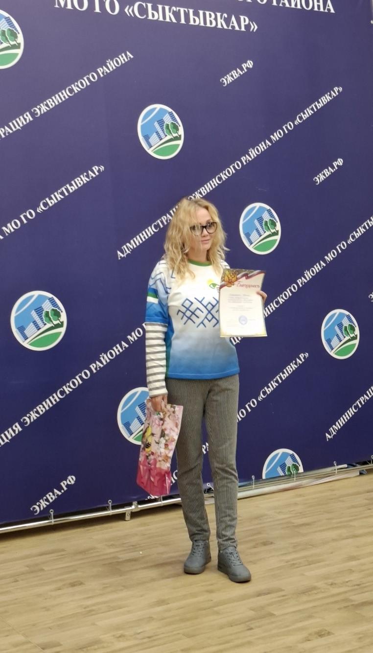 Участница турнира с грамотой на фоне баннера