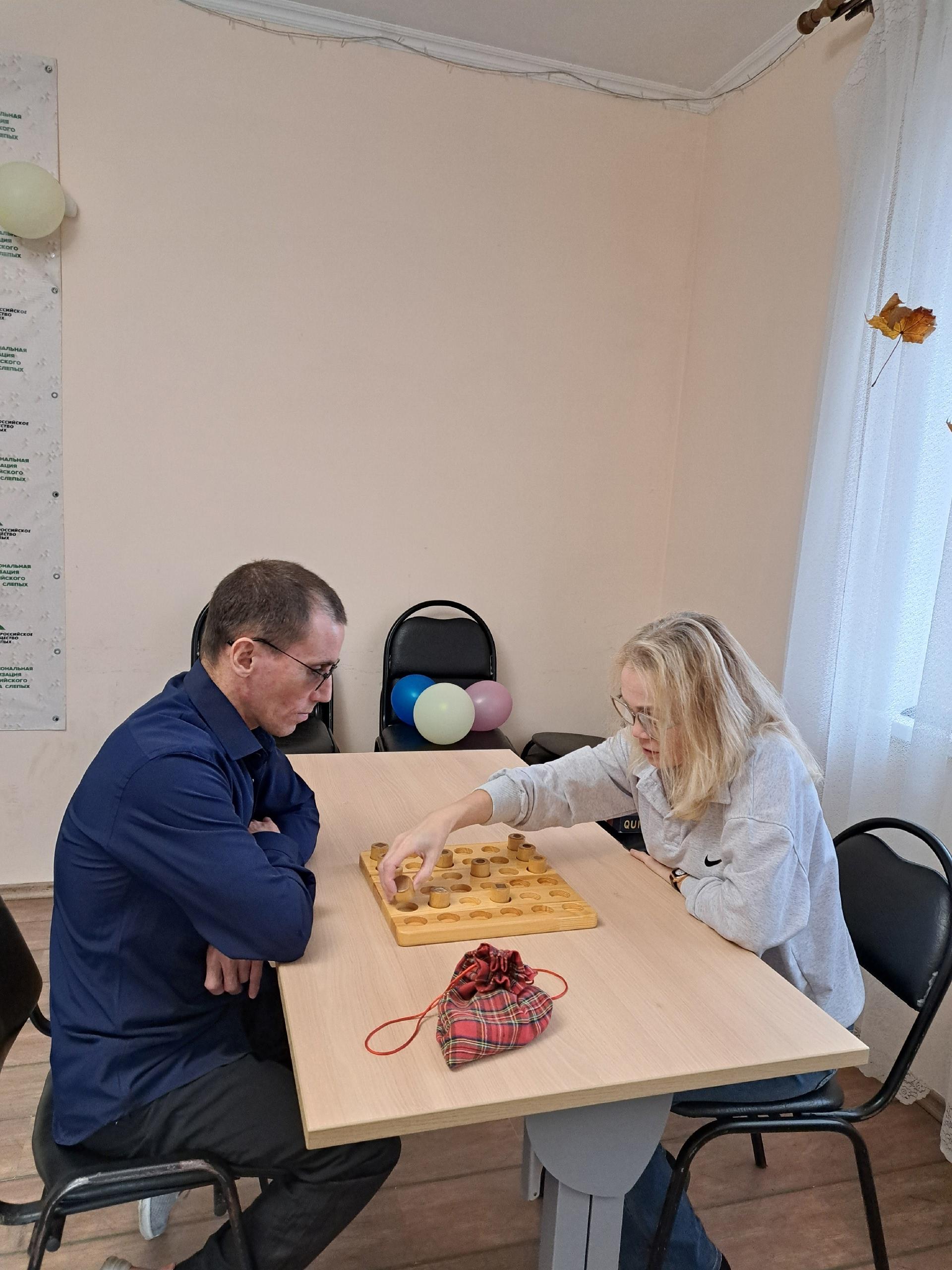 Мужчина и женщина играют в настольную игру за деревянным столом