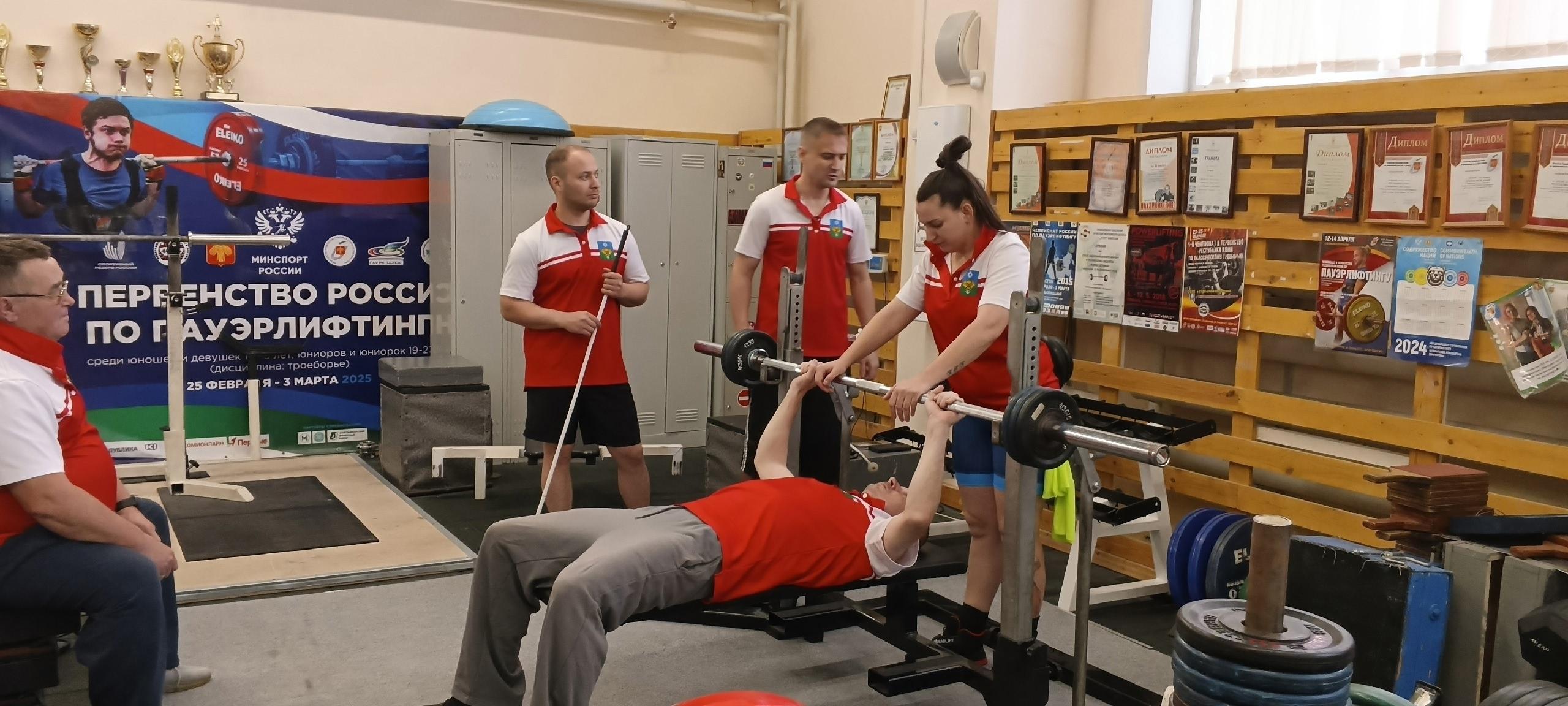 Спортсмен готовится к выполнению упражнения со штангой в зале