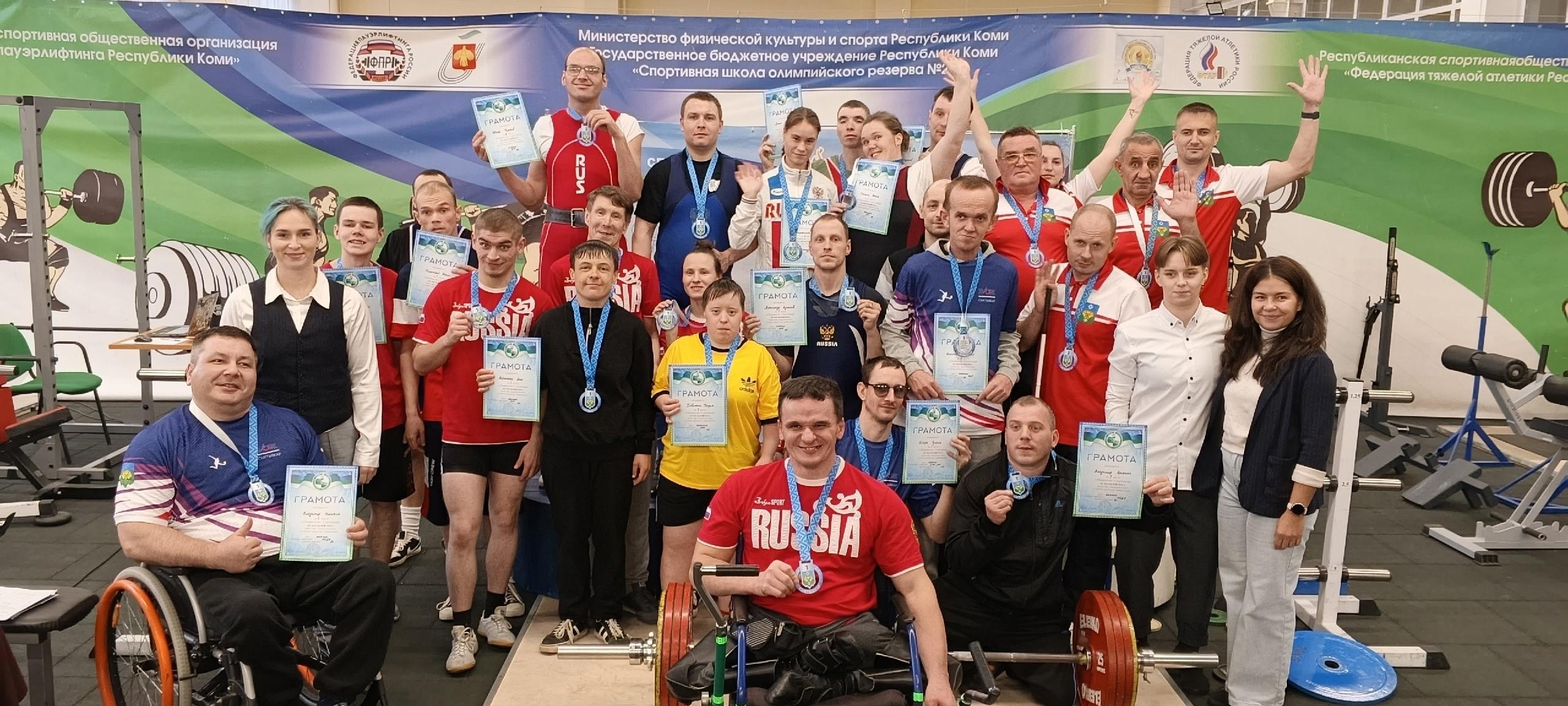 Групповое фото призеров соревнований по пауэрлифтингу с наградами