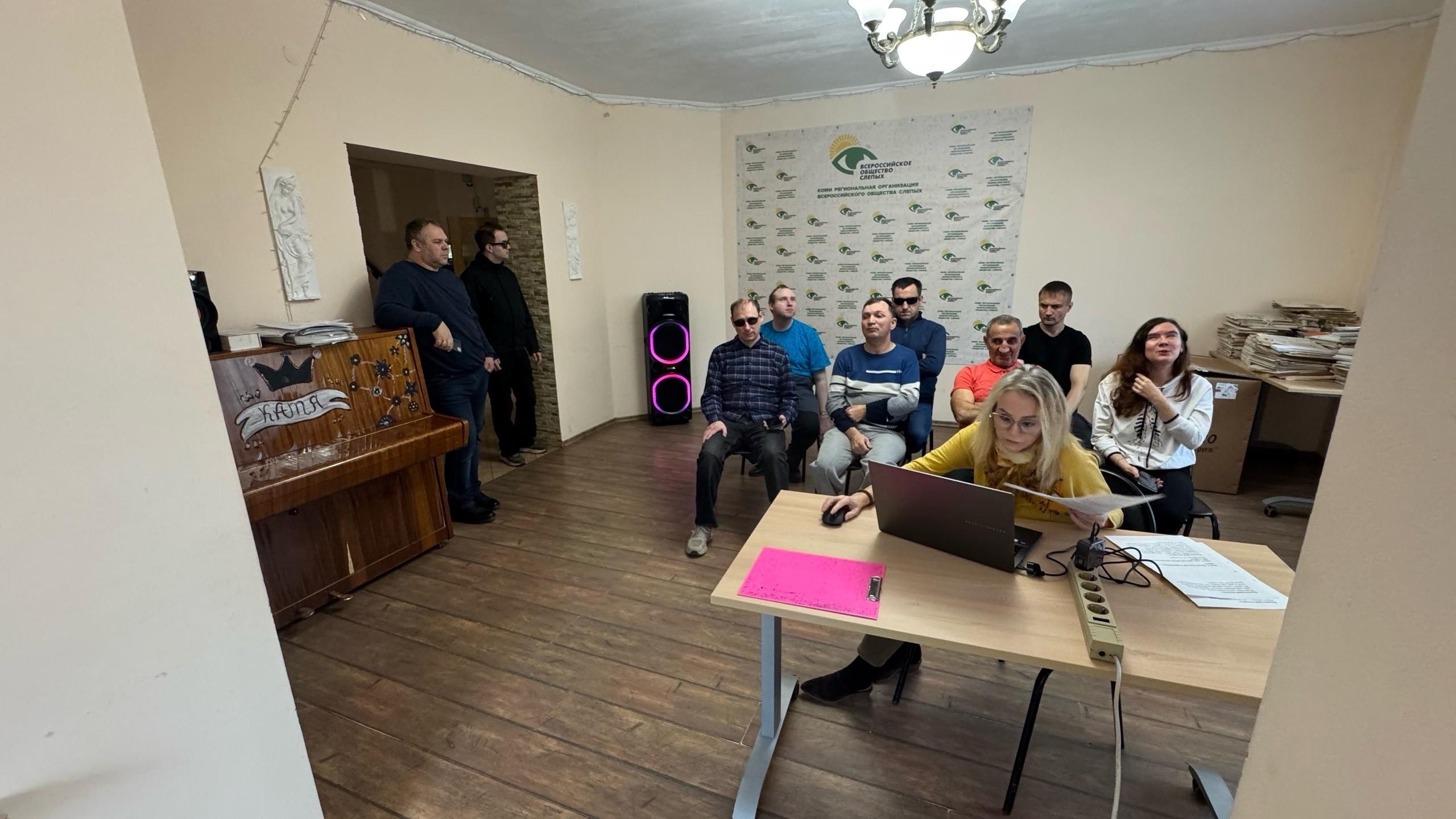 Женщина за ноутбуком выступает перед аудиторией в помещении