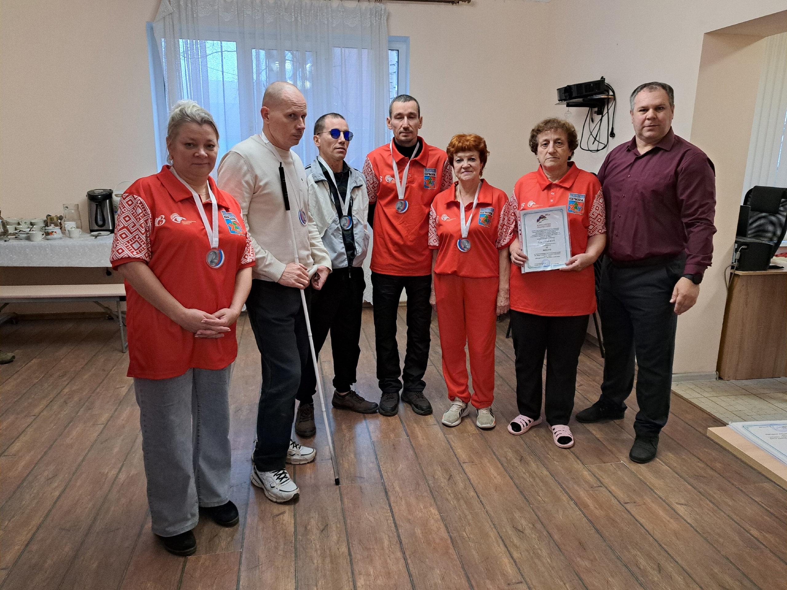 Команда участников в красной спортивной форме с медалями